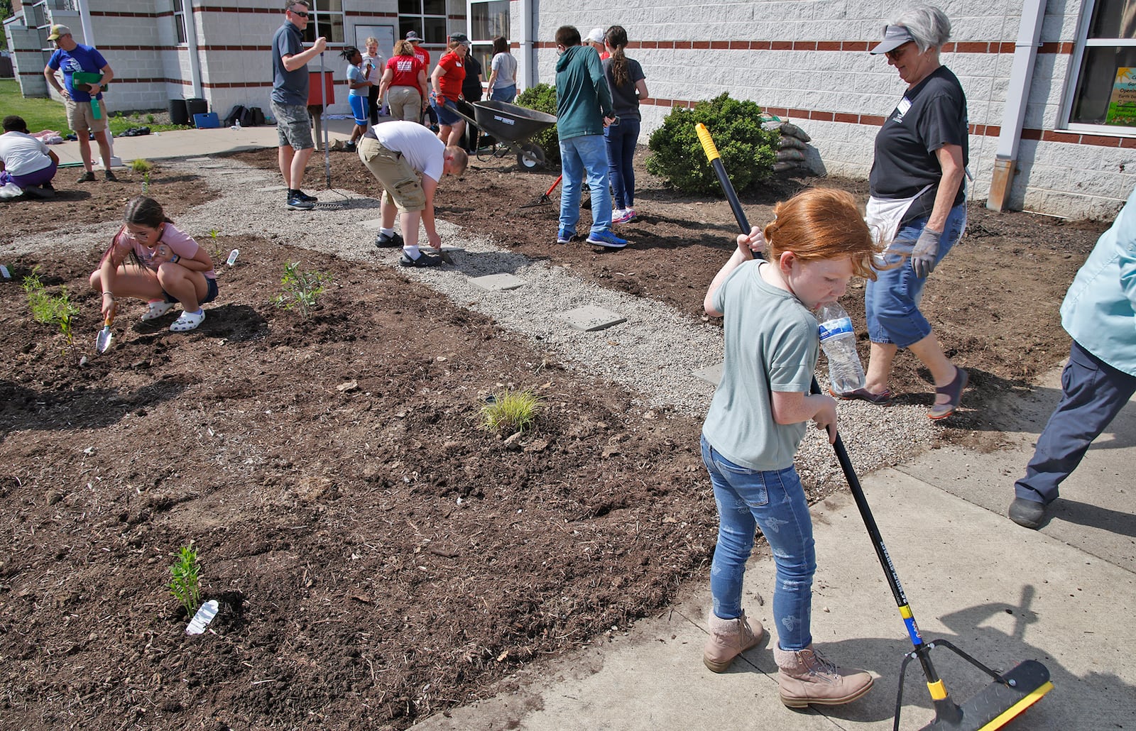 The OSU Master Gardener Volunteers helped Snyder Park Elementary students create a new pollinator garden in front of the school Tuesday, April 16, 2024. The Master Gardeners were donating their time and expertise to help the students set up their garden. The students and Master Gardeners weeded, composted and planted flowers in the garden. BILL LACKEY/STAFF