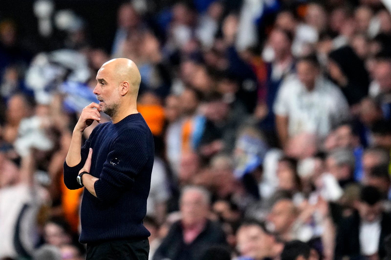 Manchester City's head coach Pep Guardiola watches the Champions League playoff second leg soccer match between Real Madrid and Manchester City at the Santiago Bernabeu Stadium in Madrid, Spain, Wednesday, Feb. 19, 2025. (AP Photo/Manu Fernandez)