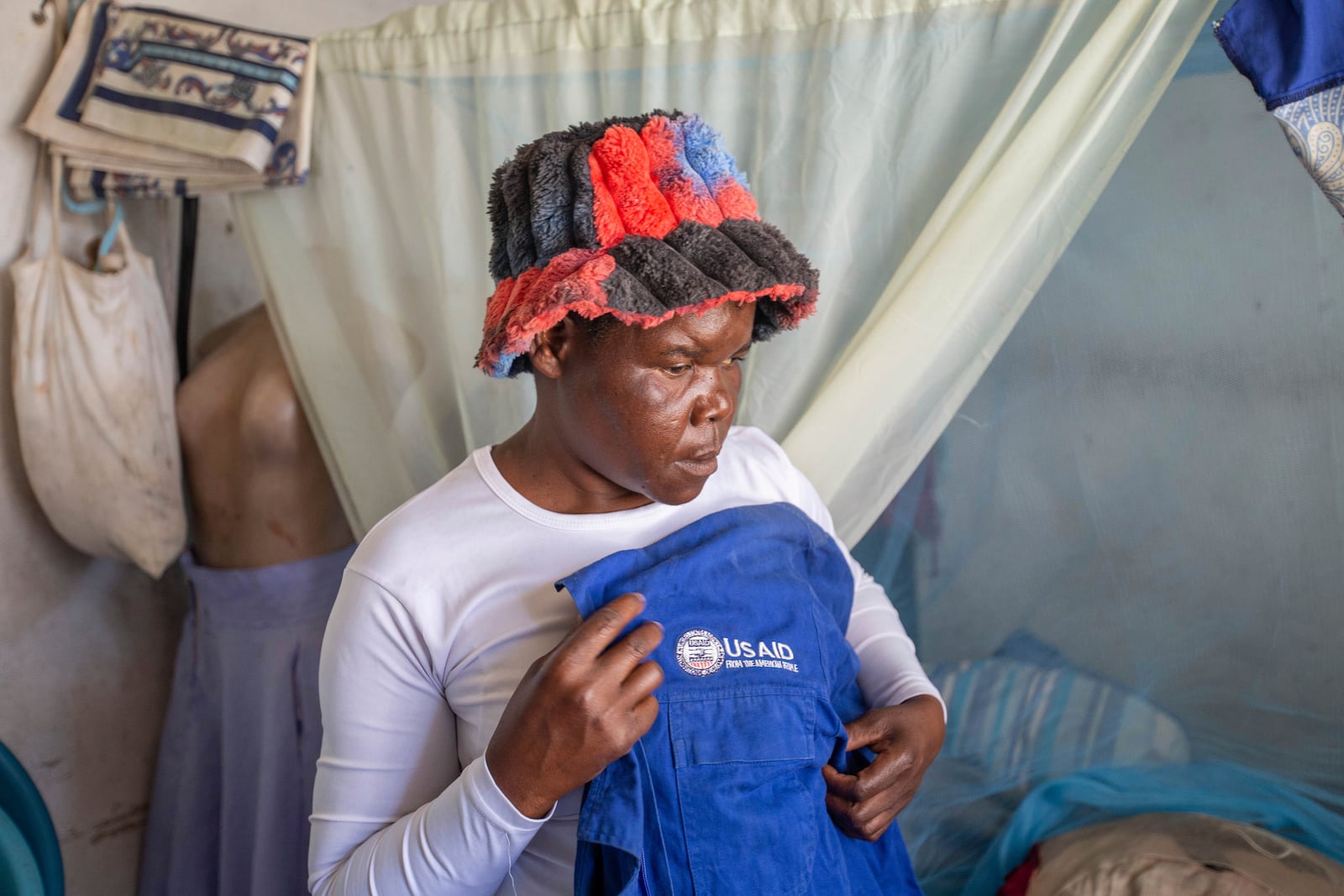 Sibusisiwe Ngalombi, 42, who is a community health worker, shows a USAID jacket she used to wear in Harare, Zimbabwe, Friday, Feb. 7, 2025. (AP Photo/Aaron Ufumeli)