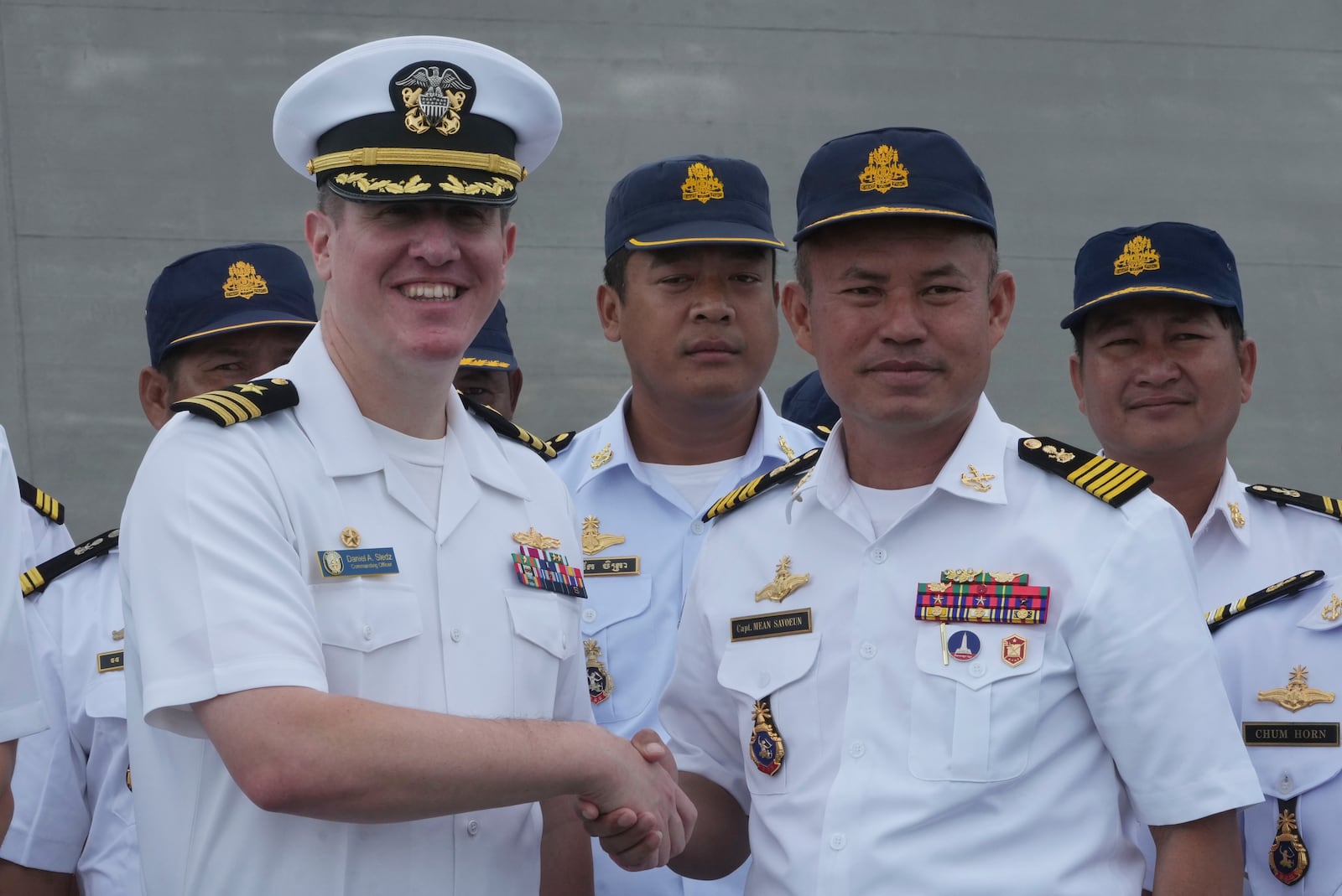 Daniel A. Sledz, left, commanding officer of USS Savannah, shakes hands with Cambodian Deputy Commander of Ream Naval Base, Capt. Mean Savoeun, front right, as it arrives for a port call at Sihanoukville port, Cambodia, Monday, Dec. 16, 2024. (AP Photo/Heng Sinith)