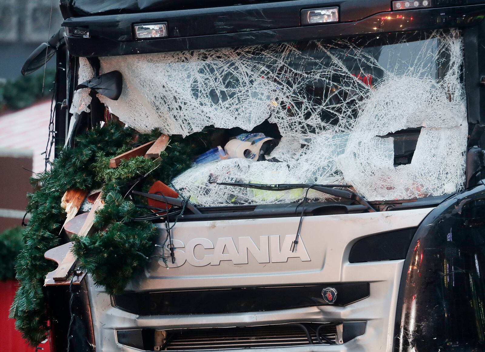 FILE - In this Dec. 20, 2016 file photo Christmas decoration sticks in the smashed window of the cabin of a truck which ran into a crowded Christmas market Monday evening killing several people in Berlin, Germany. (AP Photo/Markus Schreiber, file)