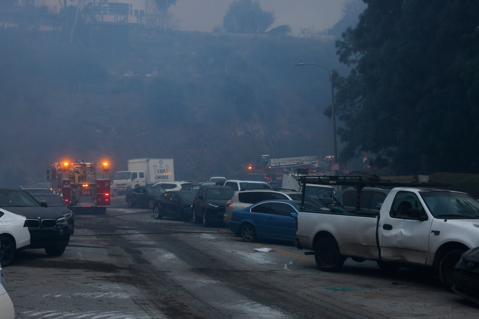 Vehicles are left stranded off the side of the road after residents tried to flee from the Palisades Fire in the Pacific Palisades neighborhood of Los Angeles, Tuesday, Jan. 7, 2025. (AP Photo/Etienne Laurent)