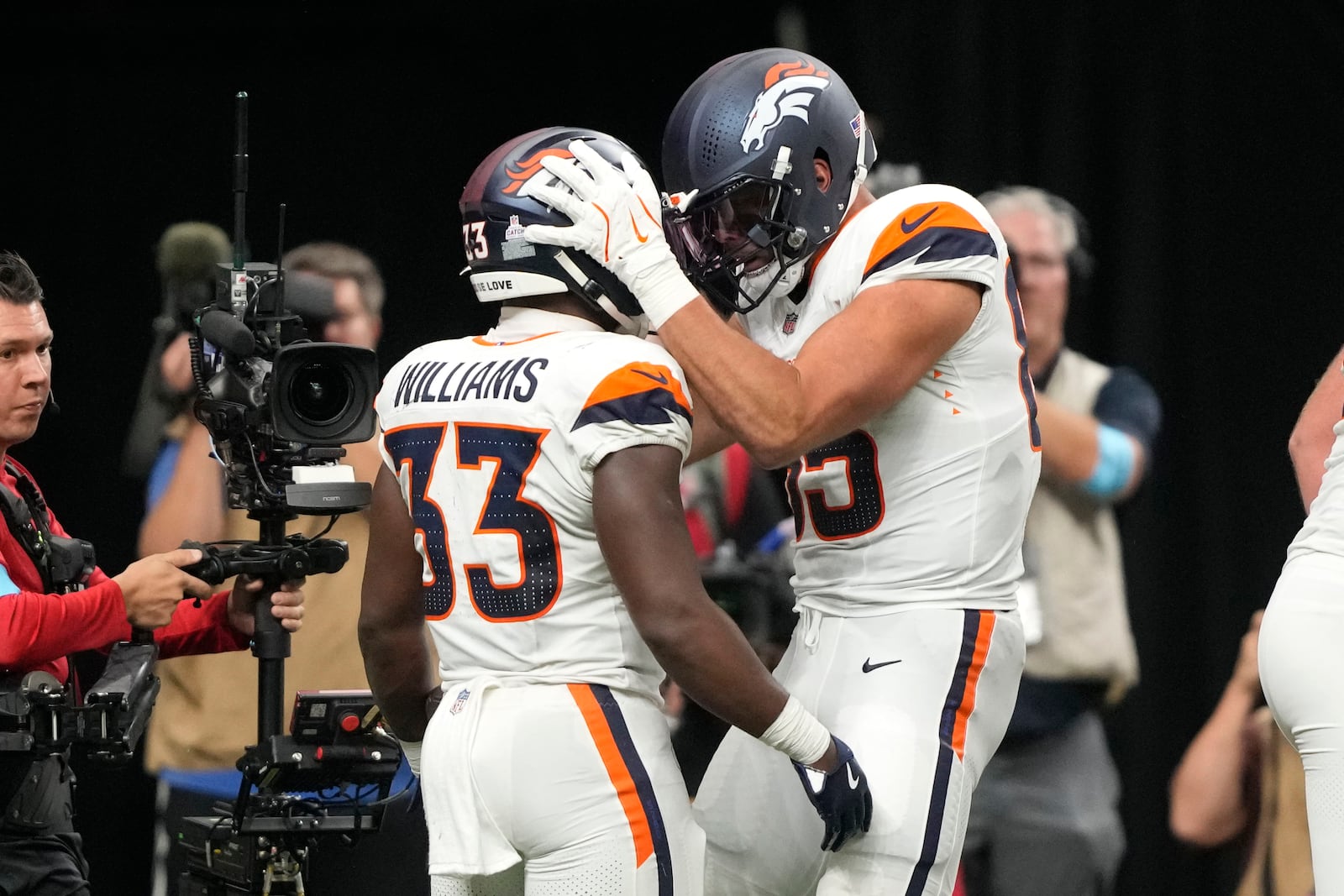 Denver Broncos running back Javonte Williams (33) celebrates with teammate tight end Lucas Krull (85) after an 8-yard touchdown run during the first half of an NFL football game against the New Orleans Saints, Thursday, Oct. 17, 2024, in New Orleans. (AP Photo/Gerald Herbert)