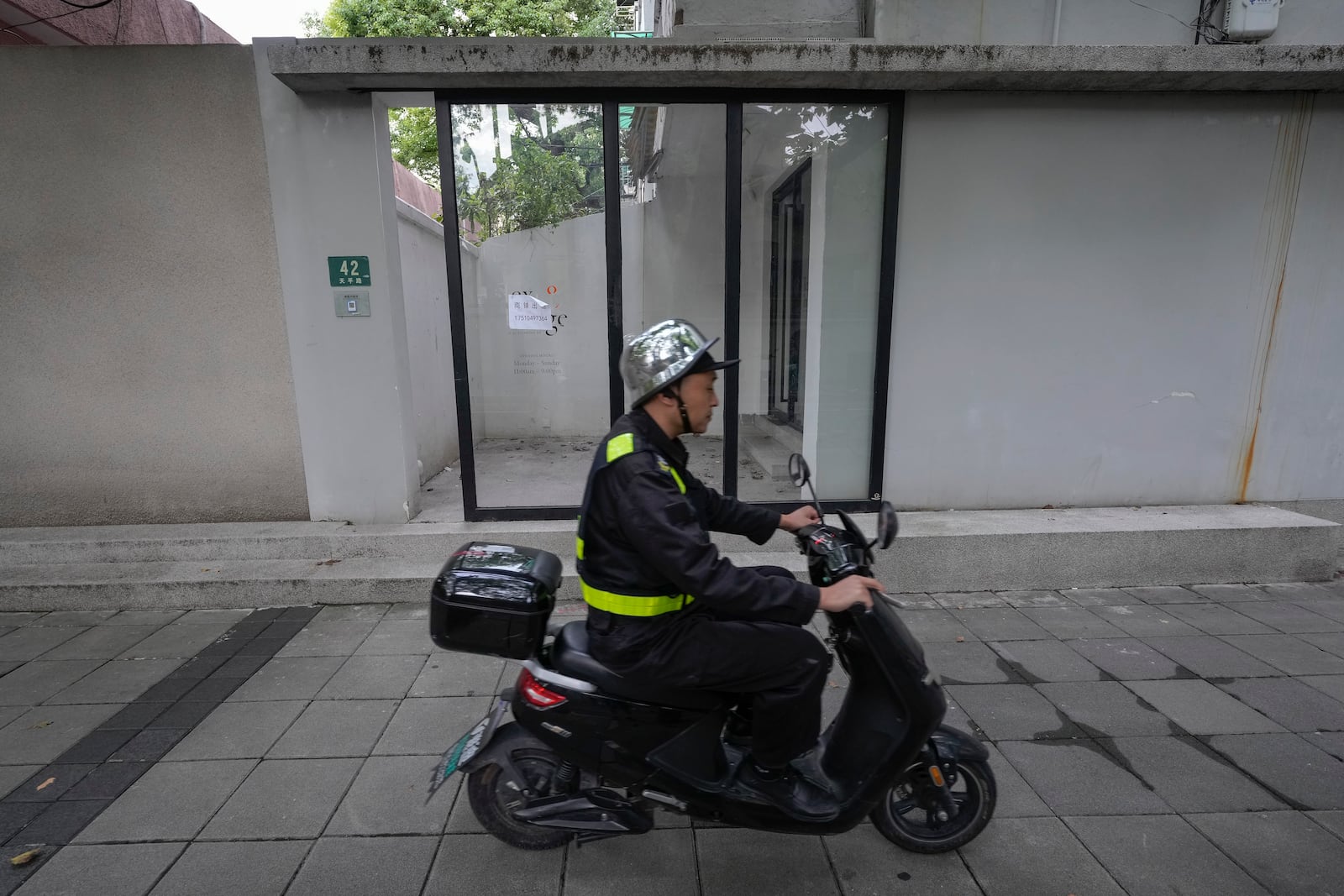 A man rides past the shuttered Text&Image bookstore in Shanghai, Oct. 9, 2024. (AP Photo/Andy Wong)