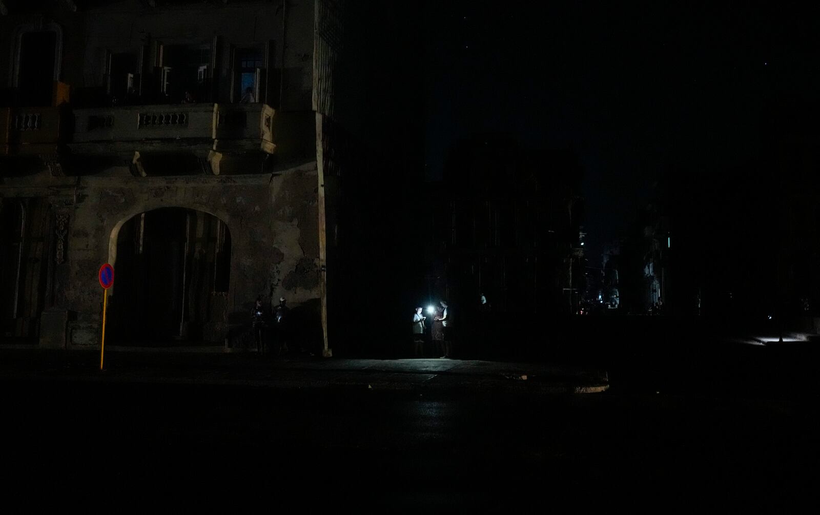 Residents illuminate themselves with flashlights during a general blackout in Havana, Saturday, March 15, 2025. (AP Photo/Ramon Espinosa)