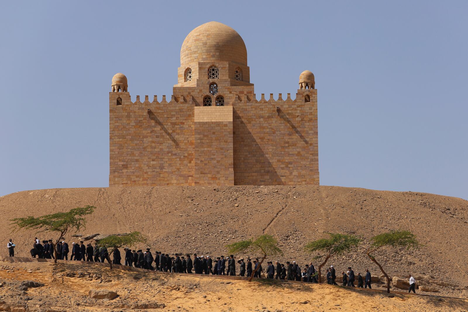 Relatives of Prince Karim Al-Hussaini, the Aga Khan IV and 49th hereditary imam of the Shiite Ismaili Muslims, who died Tuesday in Portugal, walk during a funeral ceremony at the Aga Khan mausoleum, in Aswan, Egypt, Sunday, Feb. 9, 2025. (AP Photo/Haytham Fahmy)