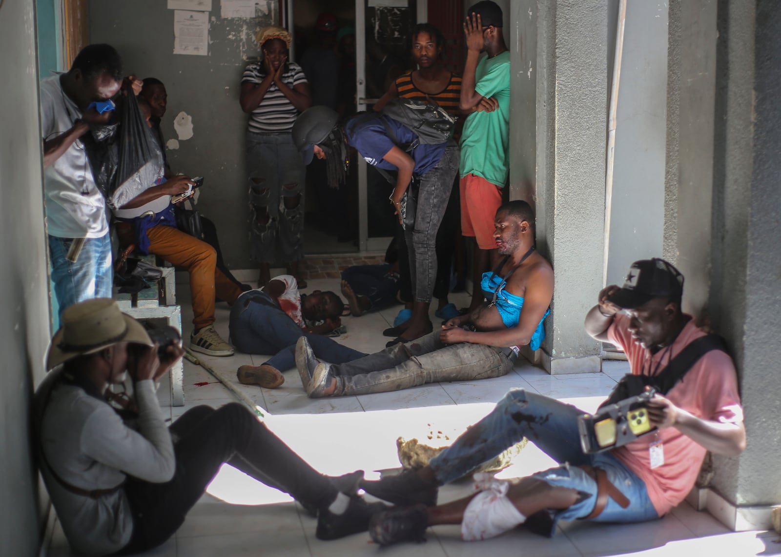 Journalists sit wounded after being shot by armed gangs at the General Hospital in Port-au-Prince, Haiti, Tuesday, Dec. 24, 2024. (AP Photo/Jean Feguens Regala)