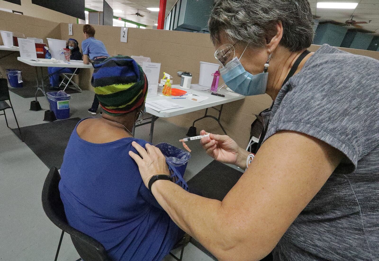 Peggy Smith, a registered nurse, gives a Springfield resident her COVID vaccine shot in September at the Clark County Combined Health District's new vaccination center on Leffel Lane. BILL LACKEY/STAFF