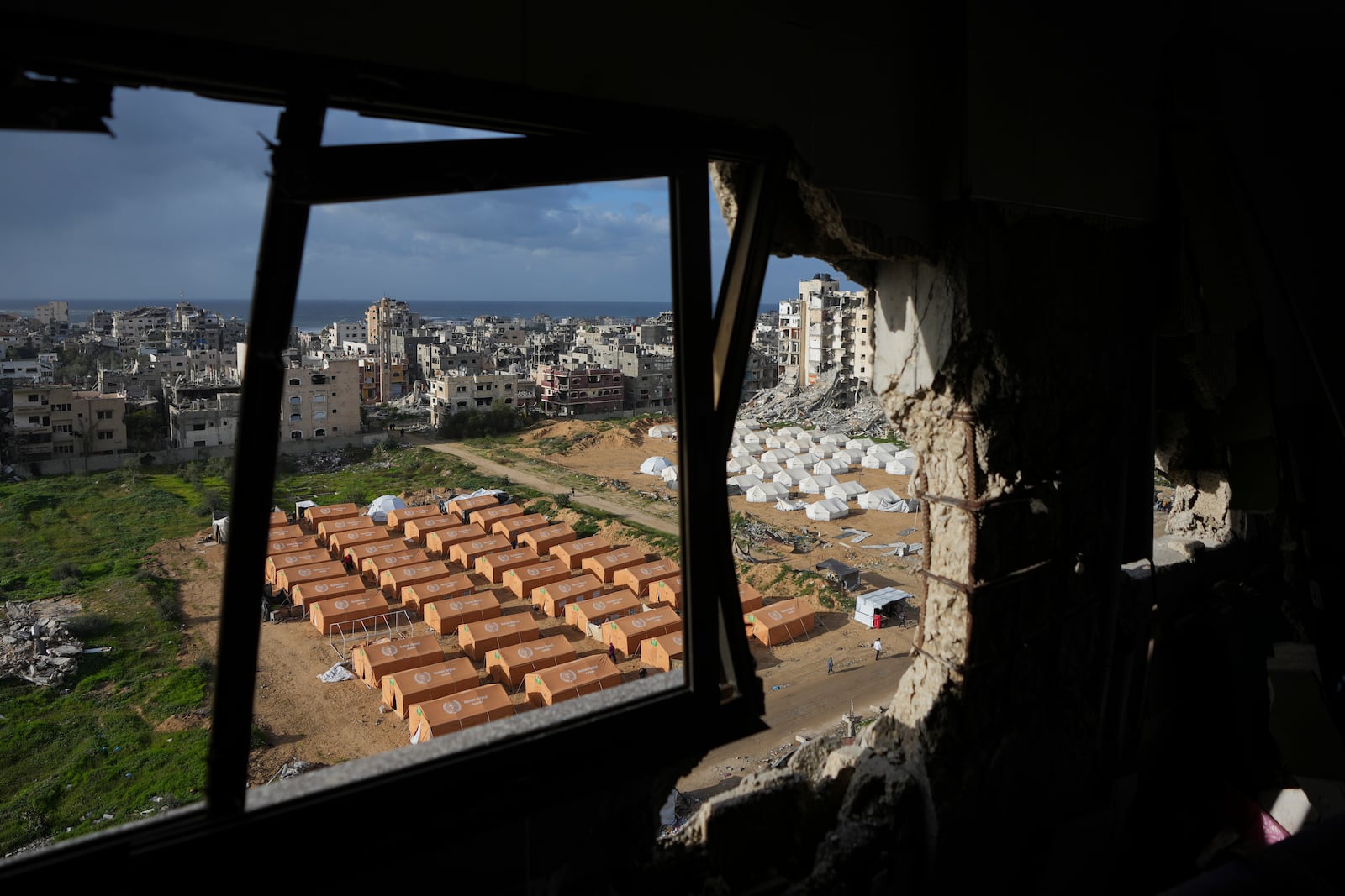 A tent camp for displaced Palestinians is set up next to destroyed buildings following the Israeli air and ground offensive in Jabaliya, Gaza Strip, Thursday, Feb. 6, 2025. (AP Photo/Abdel Kareem Hana)