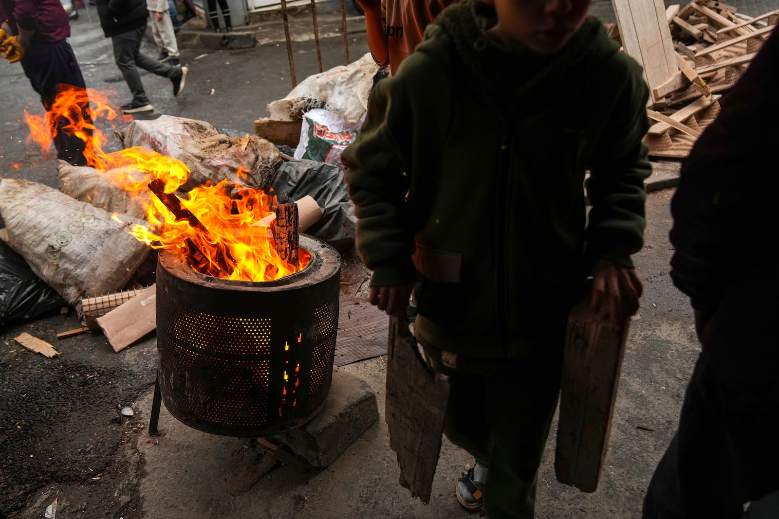 Local boys gather pieces of wood to burn for heat in the Tarlabasi neighborhood in Istanbul, Turkey, Wednesday, Dec. 4, 2024. (AP Photo/Francisco Seco)