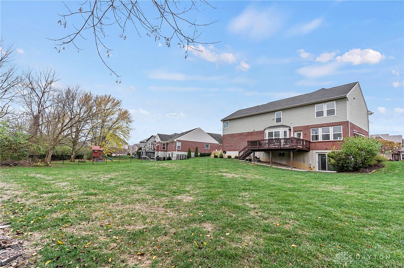 The rear of the home has an elevated wood deck with railings.