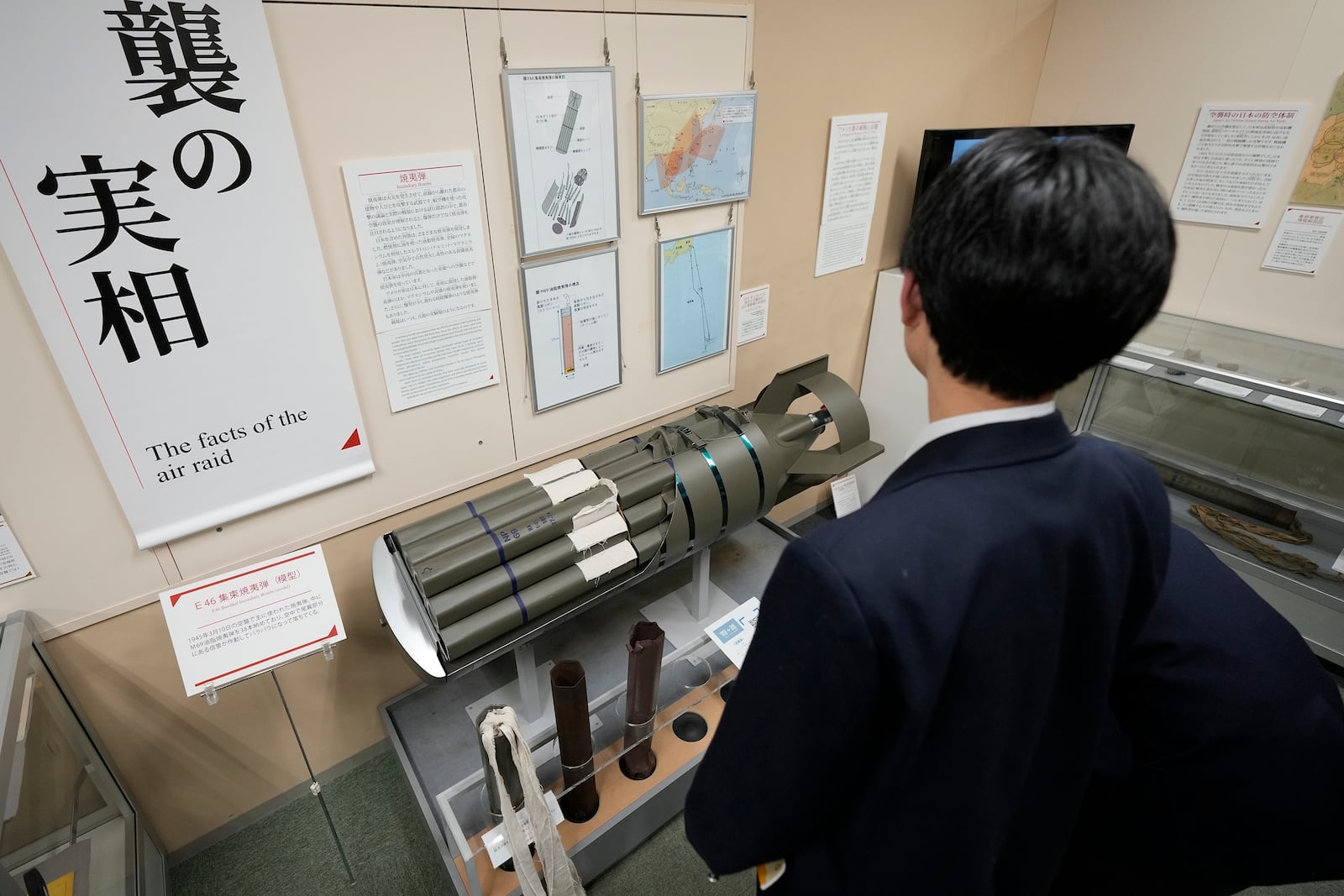 One of middle school students from Niigata on a school trip looks at model of an incendiary bomb is on display at the Center of the Tokyo Raids and War Damage, on Feb. 24, 2025, in Tokyo. (AP Photo/Eugene Hoshiko)