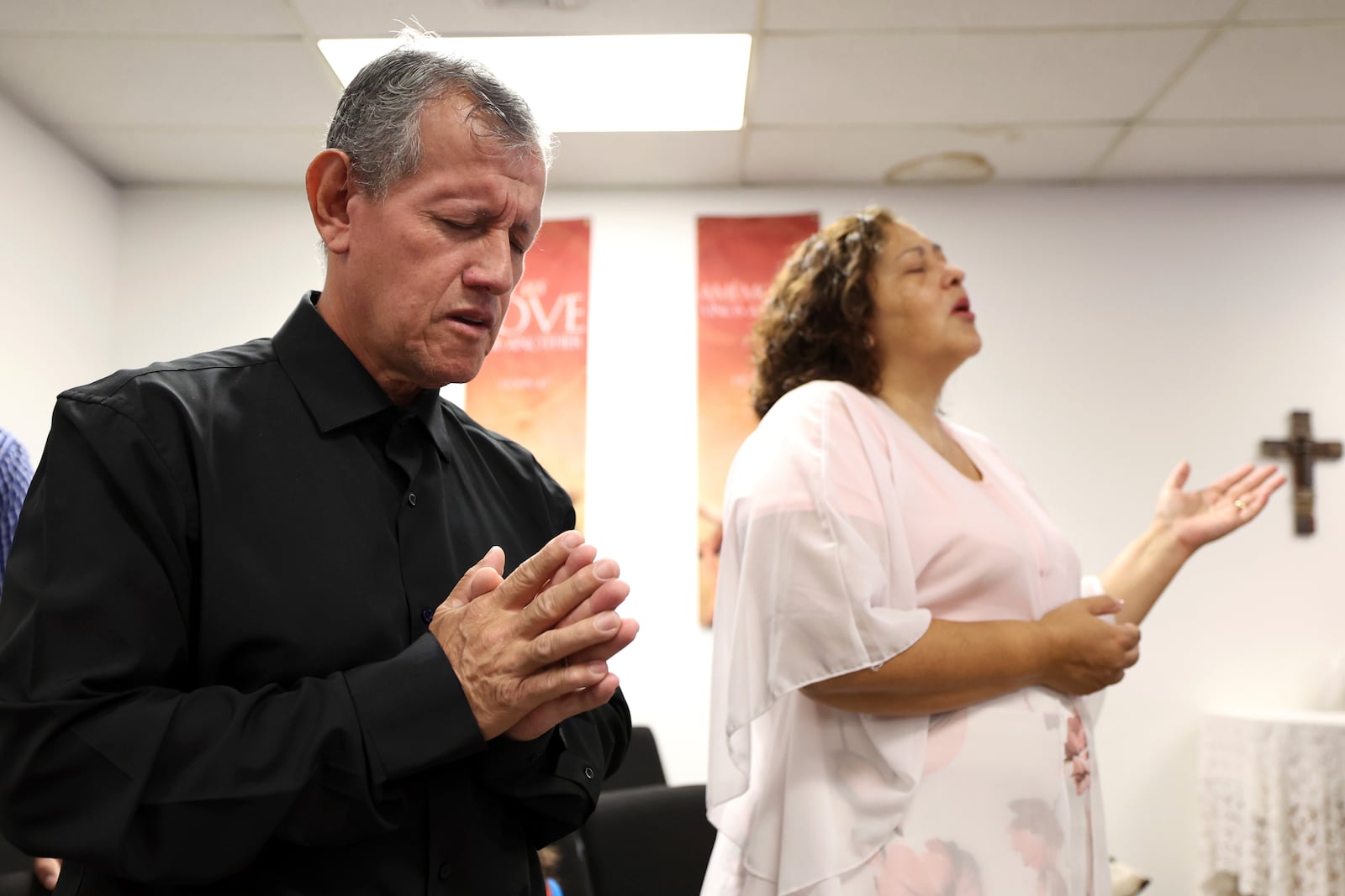 Pastor Arturo Laguna, left, prays while his wife Janett Laguna worships during services at Casa de Adoracion, Sunday, Oct. 27, 2024 in Phoenix. (AP Photo/Chris Coduto)