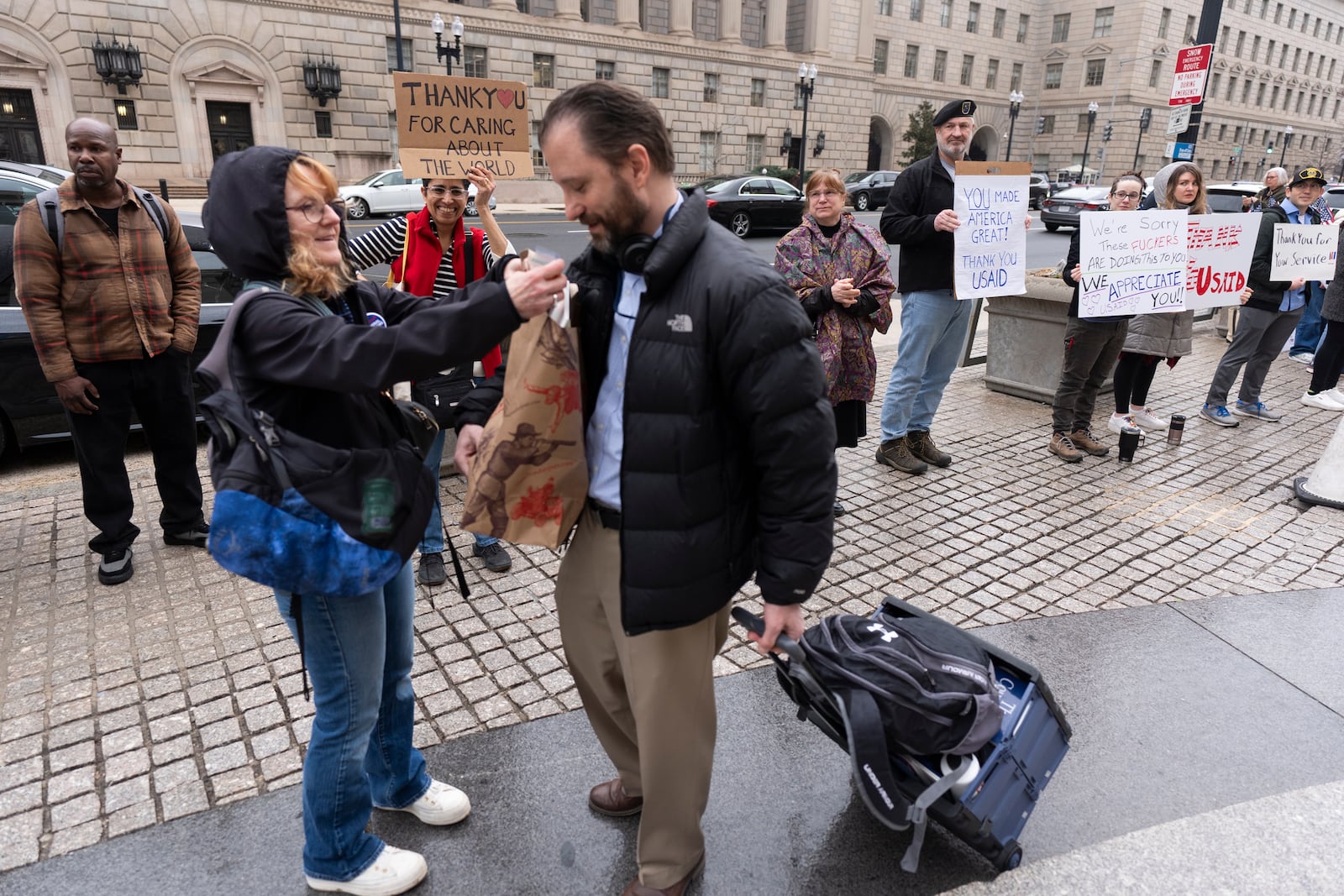 United States Agency for International Development (USAID) worker Donato Corsini carries personal belongings after retrieving them from USAID's headquarters in Washington, Thursday, Feb. 27, 2025. (AP Photo/Manuel Balce Ceneta)