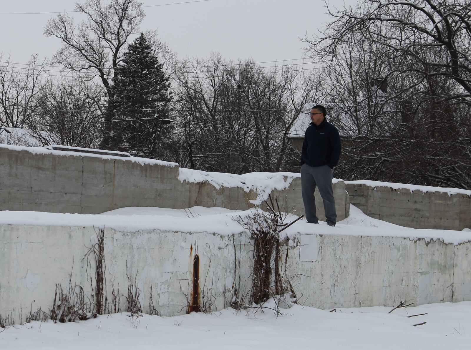 Alex Robinson stands on the foundation of what used to be a manufacturing facility located on a little over 3 acres of property on South Yellow Springs Street. Robinson purchased the land this year and hopes to build a two-story sports complex on it. Hasan Karim/ Staff