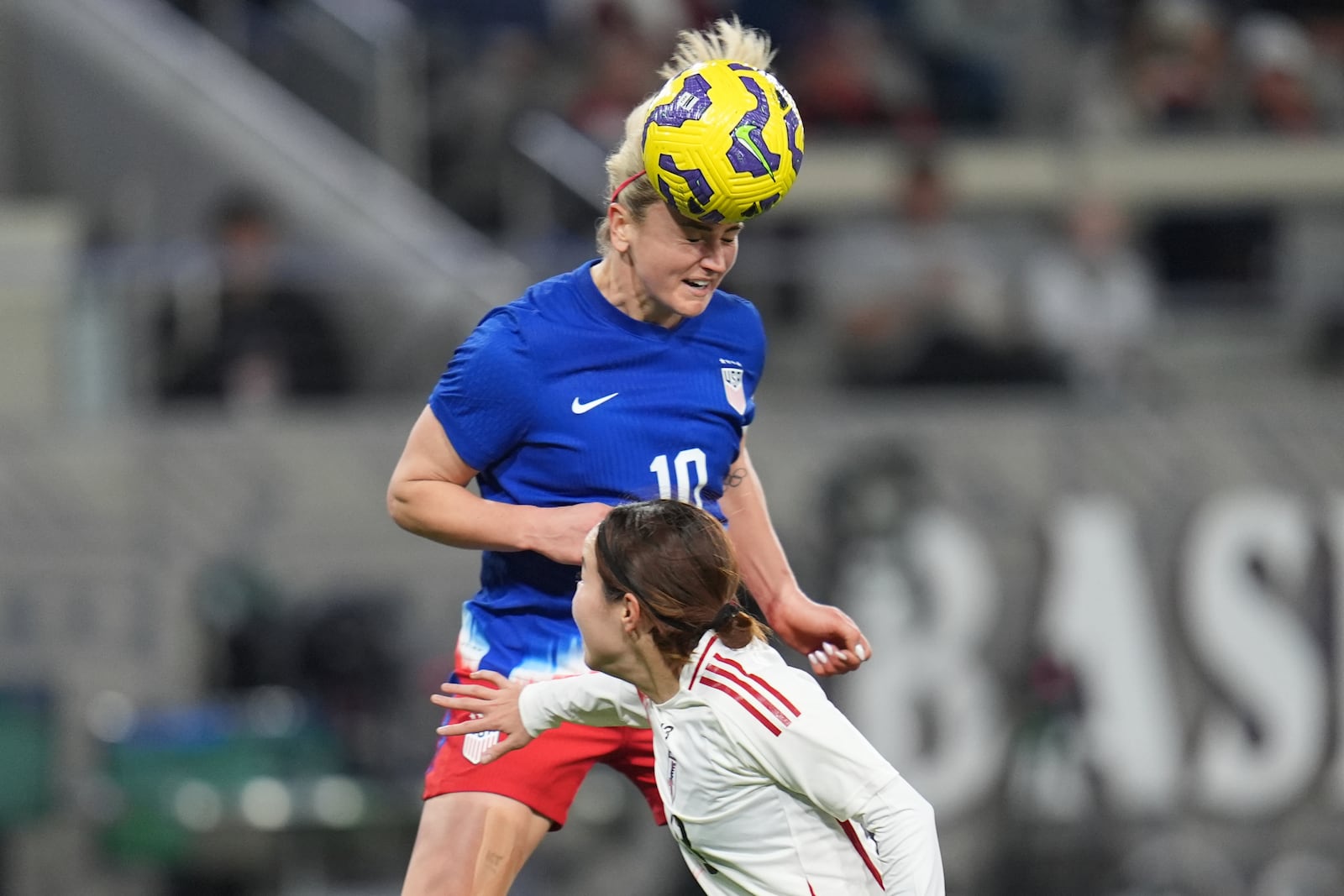 United States midfielder Lindsey Heaps heads the ball on goal as Japan defender Hikaru Kitagawa defends during the first half of a SheBelieves Cup women's soccer tournament match Wednesday, Feb. 26, 2025, in San Diego. (AP Photo/Gregory Bull)