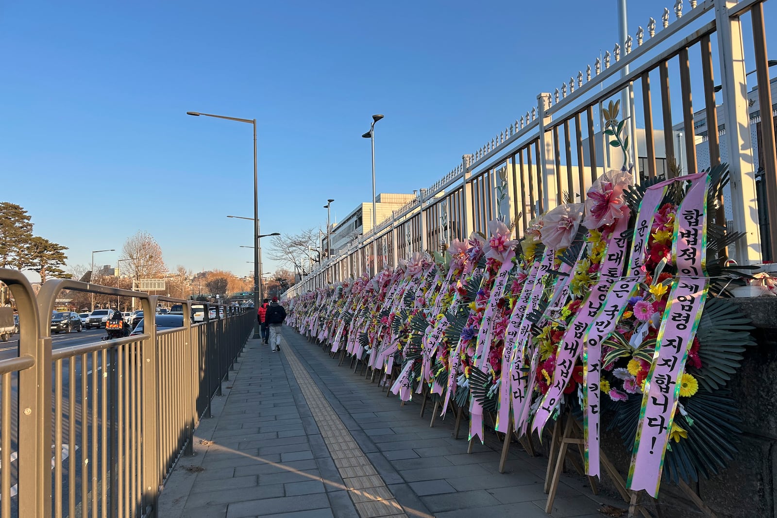 HOLD- Celebratory wreaths with messages supporting the detained President Yoon Suk Yeol line up along the street leading to his Hannam-dong residence on Thursday, Jan. 23, 2025, in Seoul. (AP Photo/Juwon Park)