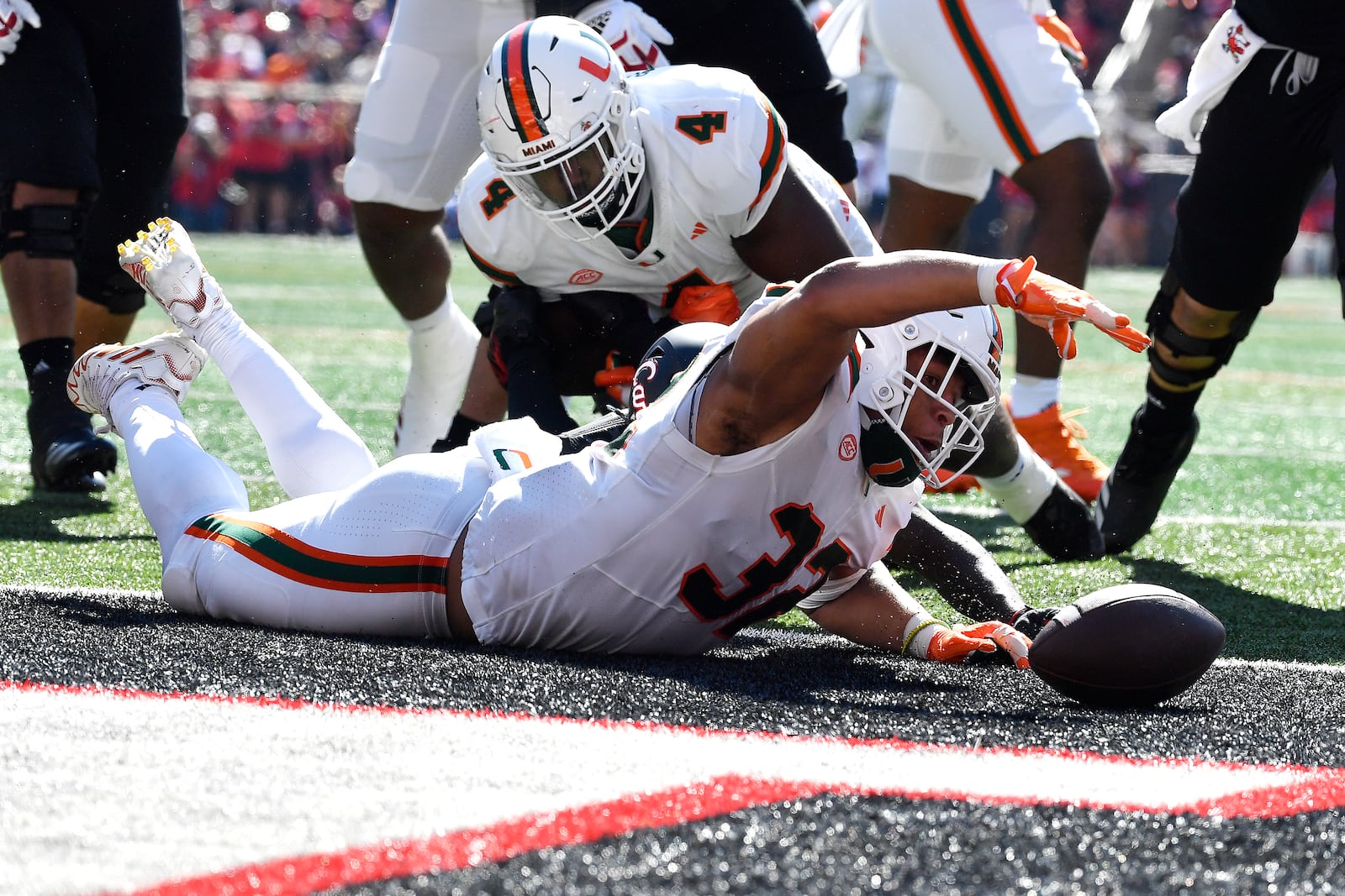 Miami linebacker Raul Aguirre Jr. (32) recovers a Louisville fumble in the end zone to score during the first half of an NCAA college football game in Louisville, Ky., Saturday, Oct. 19, 2024. (AP Photo/Timothy D. Easley)