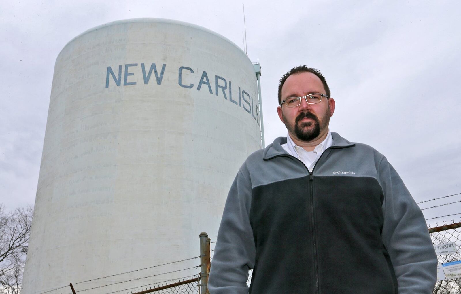 New Carlisle Mayor Mike Lowrey stand under the New Carlisle water tower. Bill Lackey/Staff