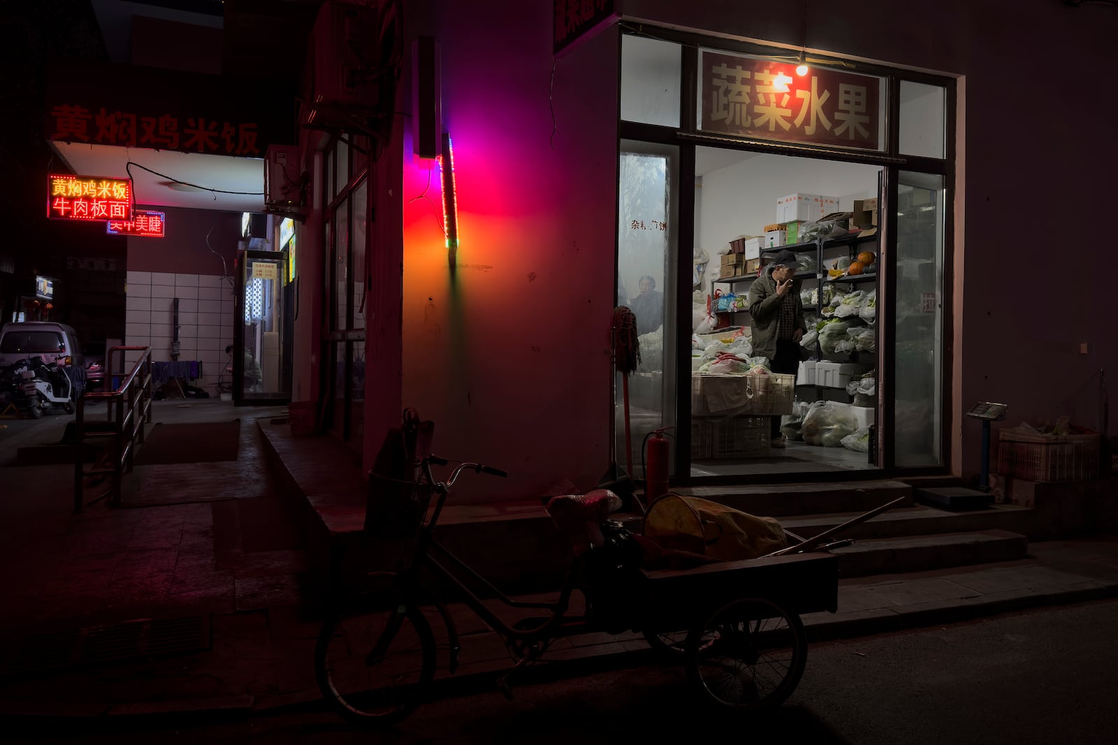 A man buys vegetable at a store near a residential area in Beijing on Saturday, March 8, 2025. (AP Photo/Andy Wong)