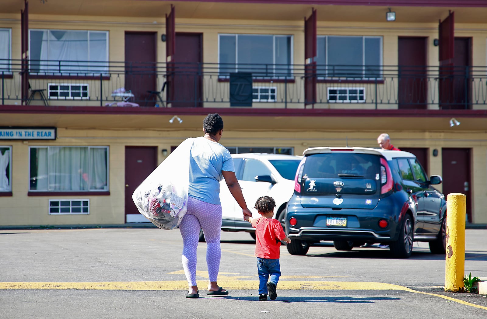 Toni Carter-White and her son carry their belongings as they leave the Executive Inn homeless shelter in Springfield on Tuesday, August 6, 2024. City Council voted the day before to reject a funding plan for the shelter. BILL LACKEY/STAFF