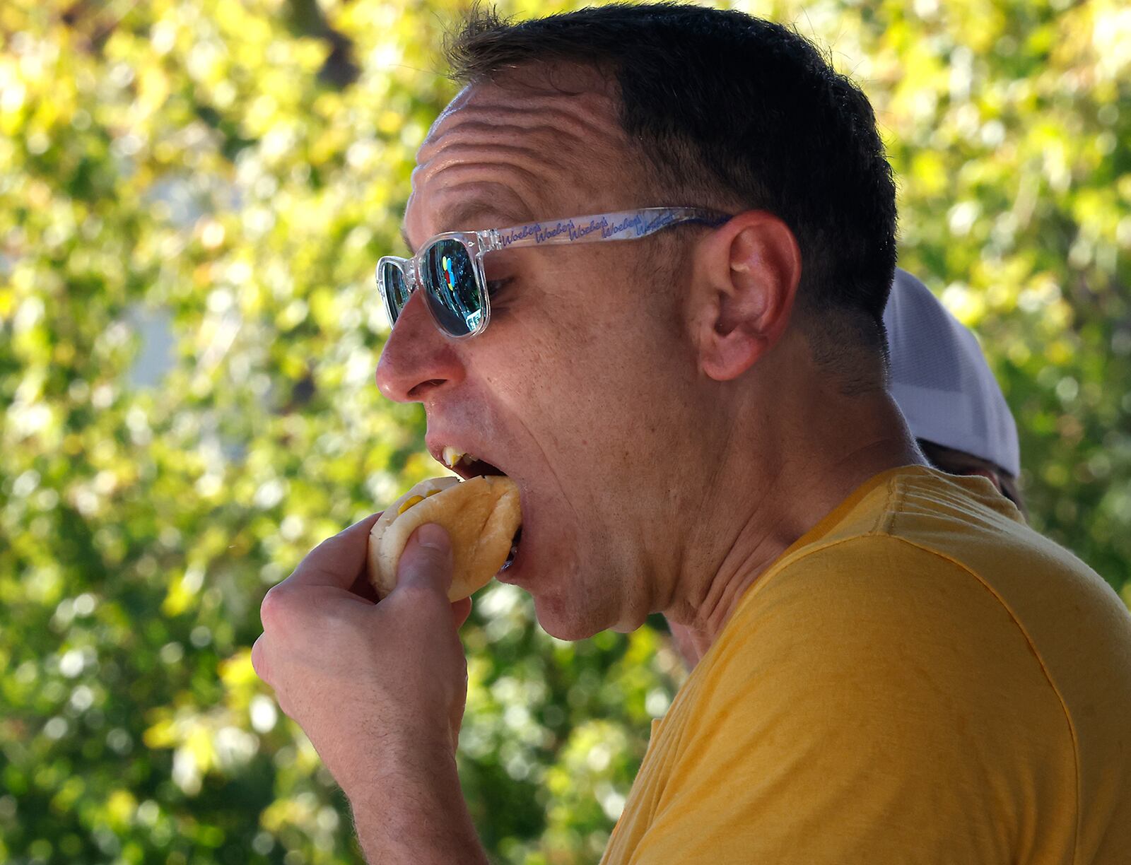 Champion competitive eater, Joey Chestnut, gives quickly devours two hot dogs in a matter of seconds as he gives a demonstration before the Woeber's Hot Mustard and Horseradish Eating Contest Saturday, Sept. 21, 2024 during Mustard Fest at National Road Commons Park. BILL LACKEY/STAFF