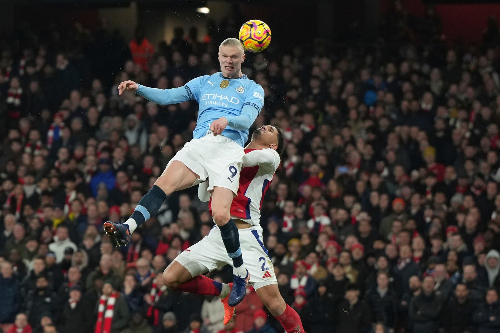 Manchester City's Erling Haaland, top, scores his side's first goal during the English Premier League soccer match between Arsenal and Manchester City at the Emirates stadium in London, Sunday, Feb. 2, 2025. (AP Photo/Alastair Grant)