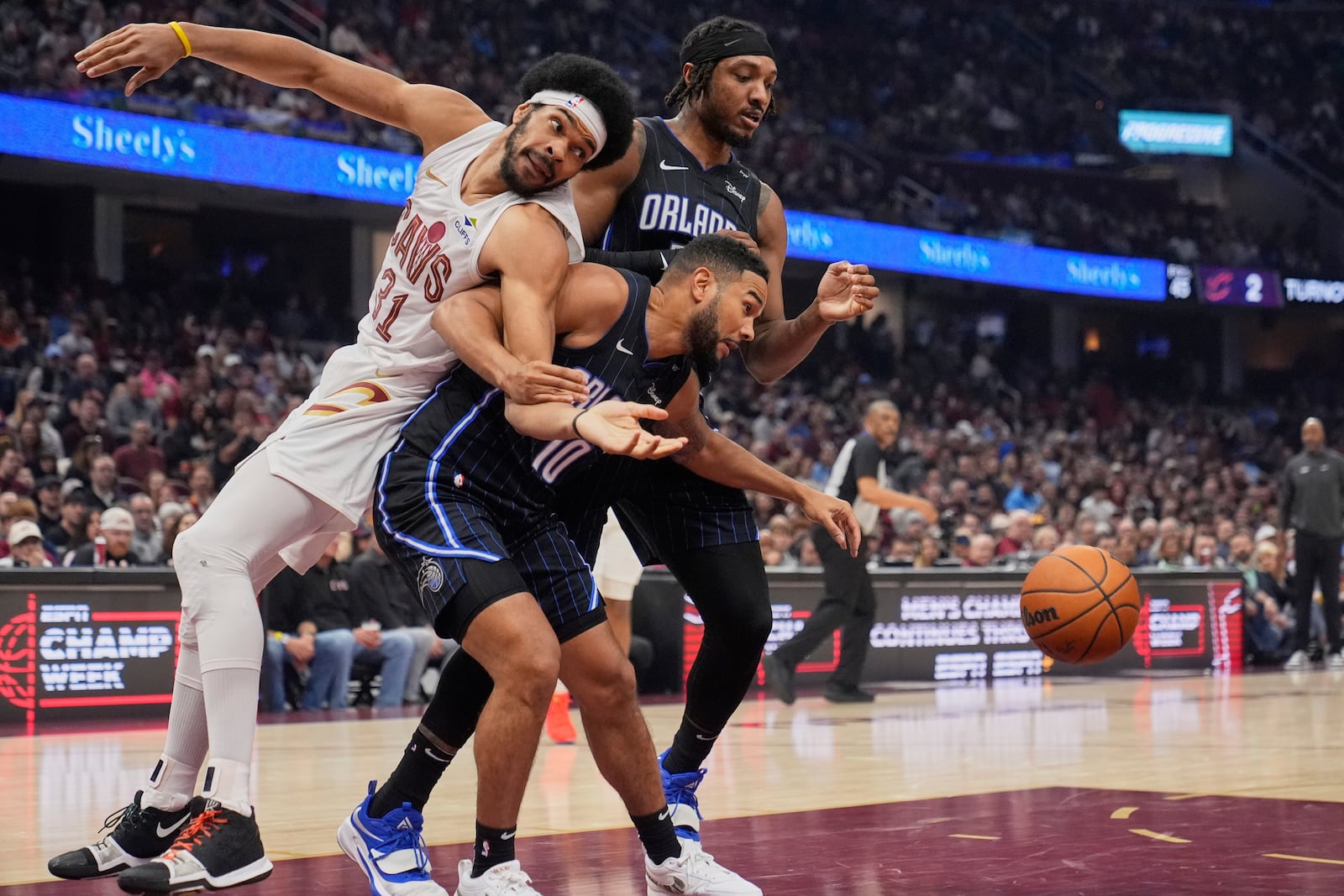 Cleveland Cavaliers center Jarrett Allen (31), Orlando Magic center Wendell Carter Jr., rear, and guard Cory Joseph (10) watch the ball in the first half of an NBA basketball game Sunday, March 16, 2025, in Cleveland. (AP Photo/Sue Ogrocki)