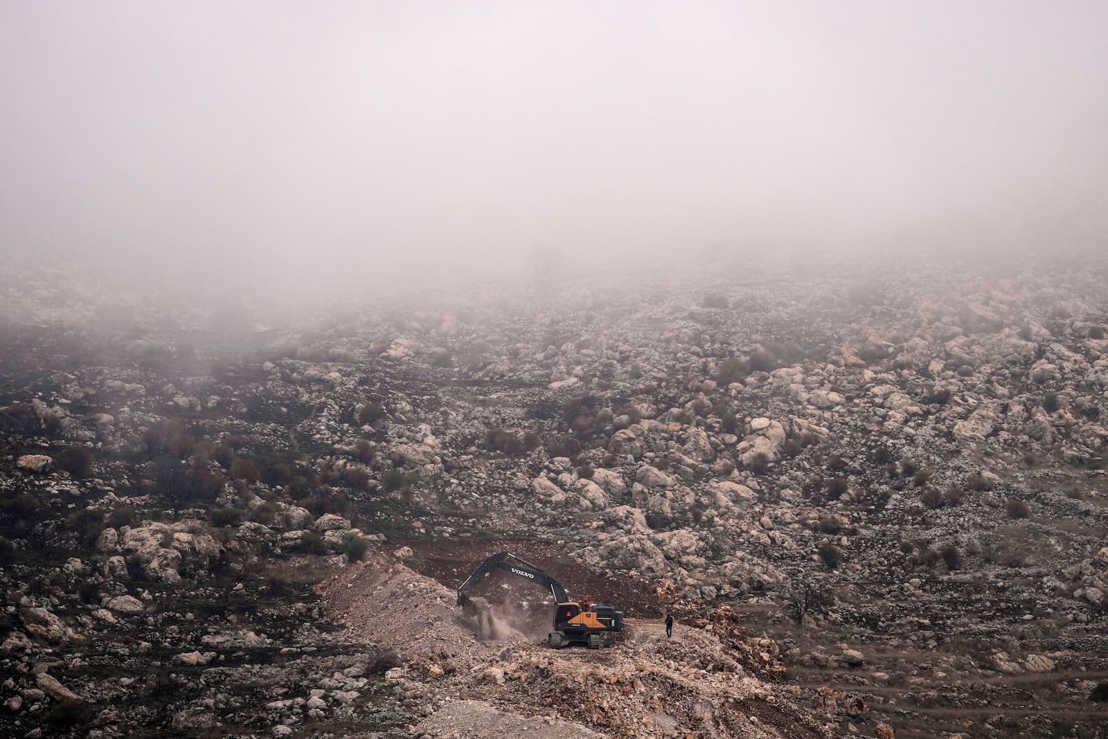 An Israeli bulldozer maneuvers on the buffer zone near the so-called Alpha Line that separates the Israeli-controlled Golan Heights from Syria, viewed from the town of Majdal Shams, Saturday, Dec. 21, 2024. (AP Photo/Matias Delacroix)