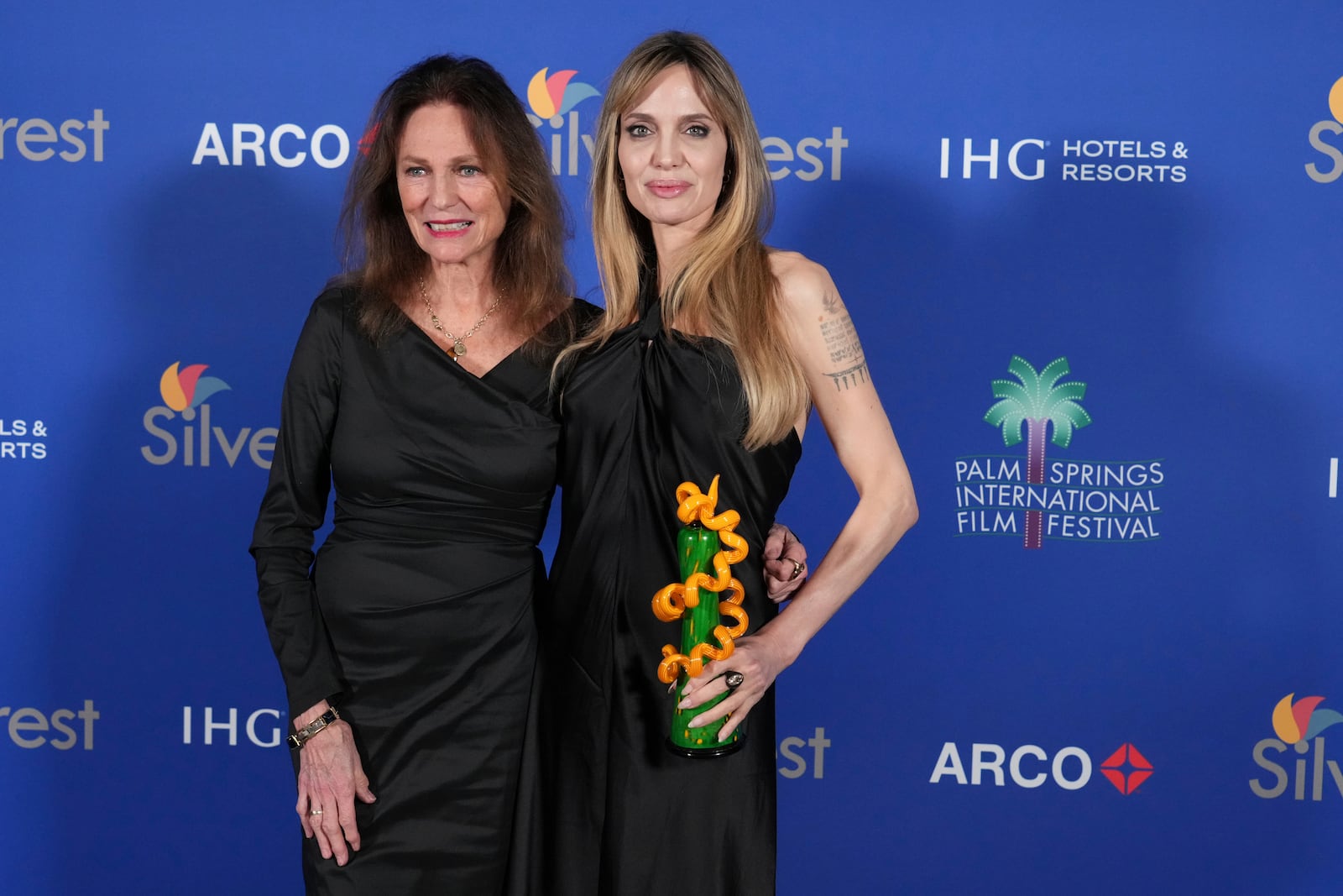 Jacqueline Bisset, left, and Angelina Jolie, winner of the desert palm achievement award, actress for "Maria", pose in the press room during the 36th annual Palm Springs International Film Festival Awards Gala on Friday, Jan. 3, 2025, in Palm Springs, Calif. (Photo by Jordan Strauss/Invision/AP)