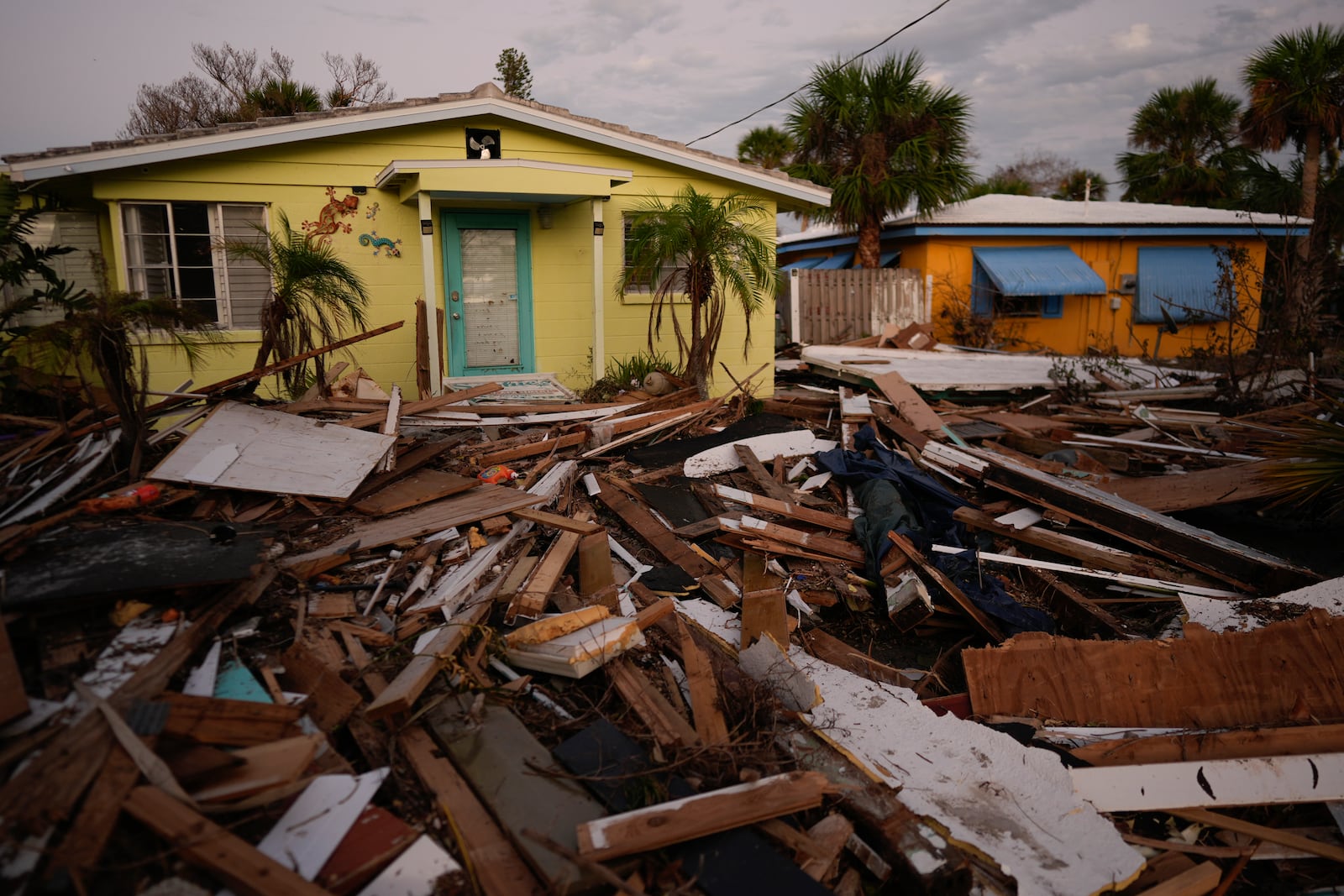 Debris from homes destroyed by Hurricane Milton lies strewn around still-standing houses on Manasota Key, Fla., Saturday, Oct. 12, 2024. (AP Photo/Rebecca Blackwell)