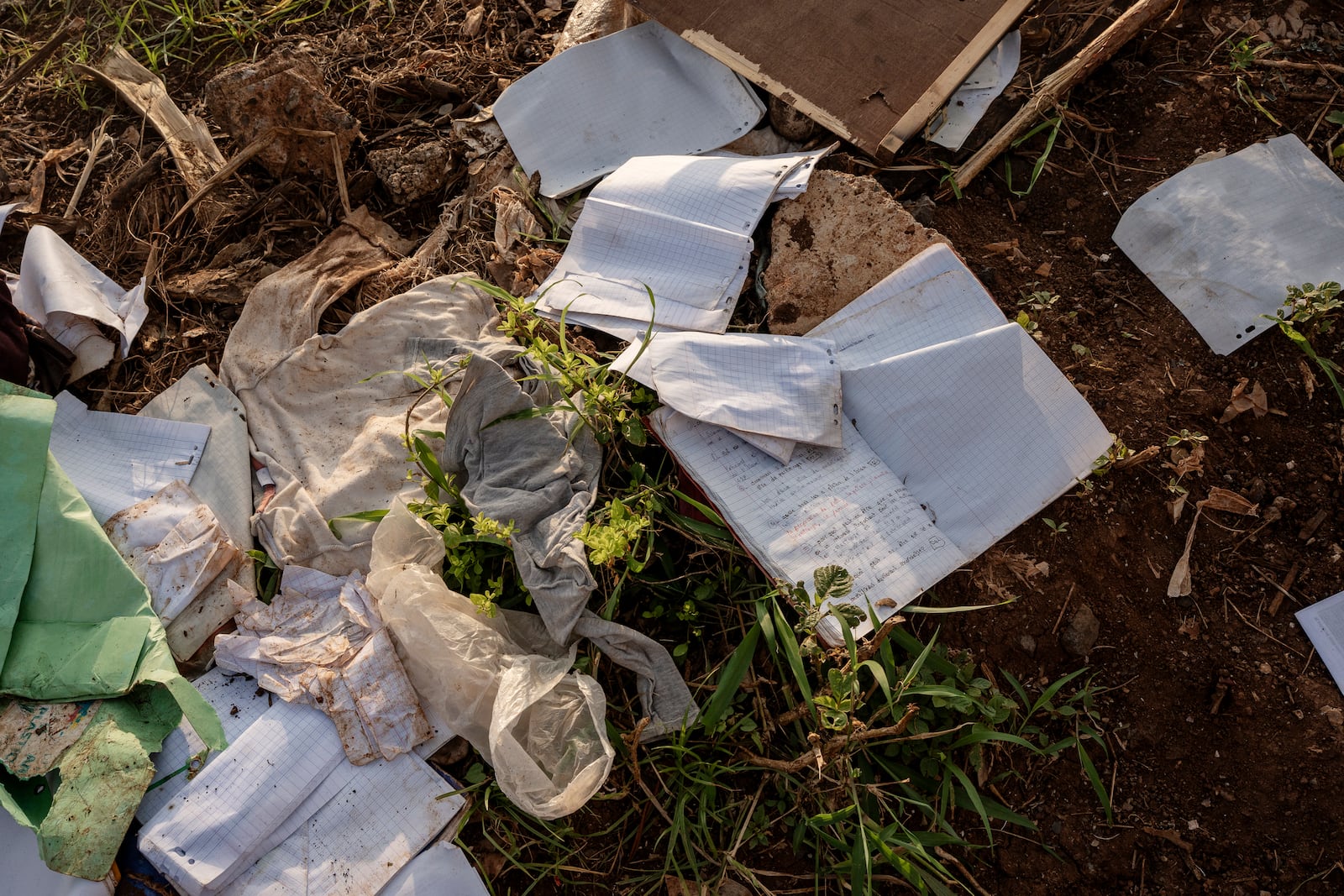 A child's school notebook lays amidst debris in Barakani, Mayotte, Saturday, Dec. 21, 2024. (AP Photo/Adrienne Surprenant)