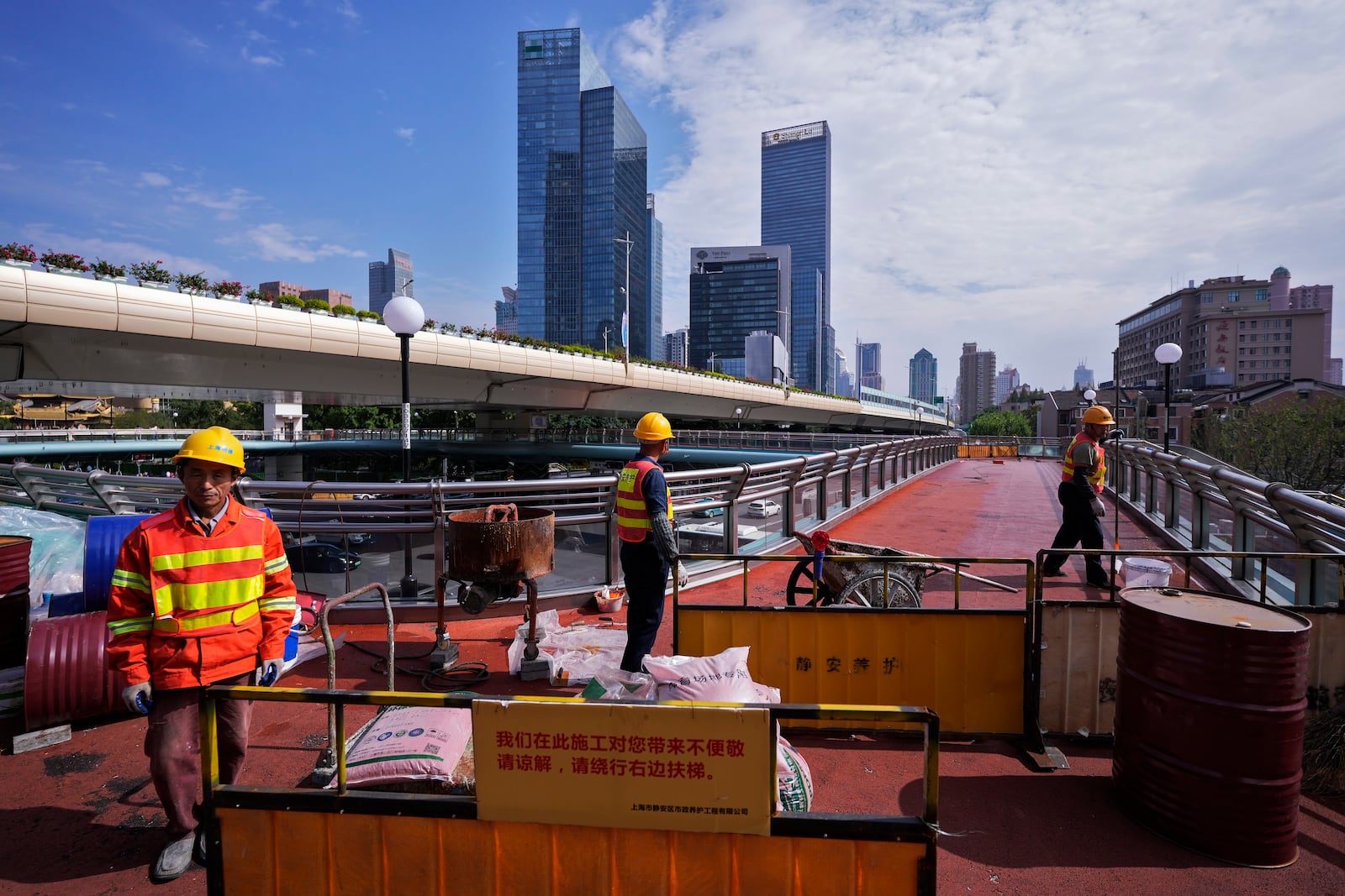 FILE - Workers refurbish an overhead pedestrian bridge in Shanghai on Oct. 9, 2024. (AP Photo/Andy Wong, File)