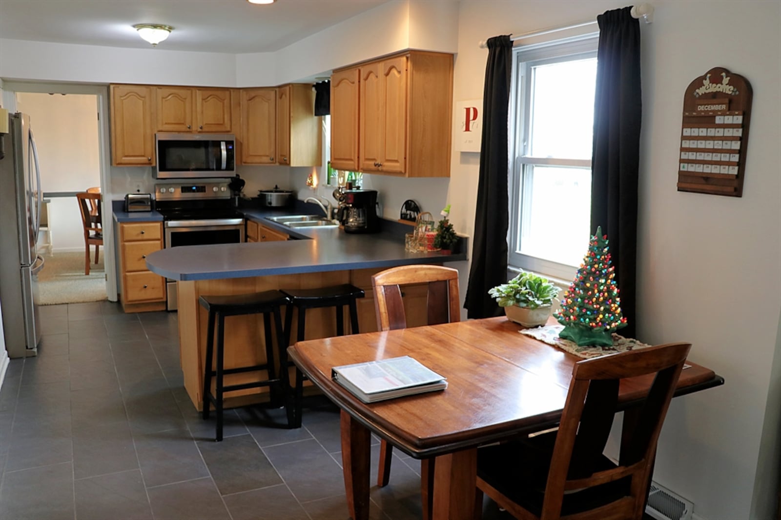 In the kitchen, cabinetry surrounds stainless-steel appliances that were new in 2019. Appliances include a range, dishwasher, microwave and refrigerator. 