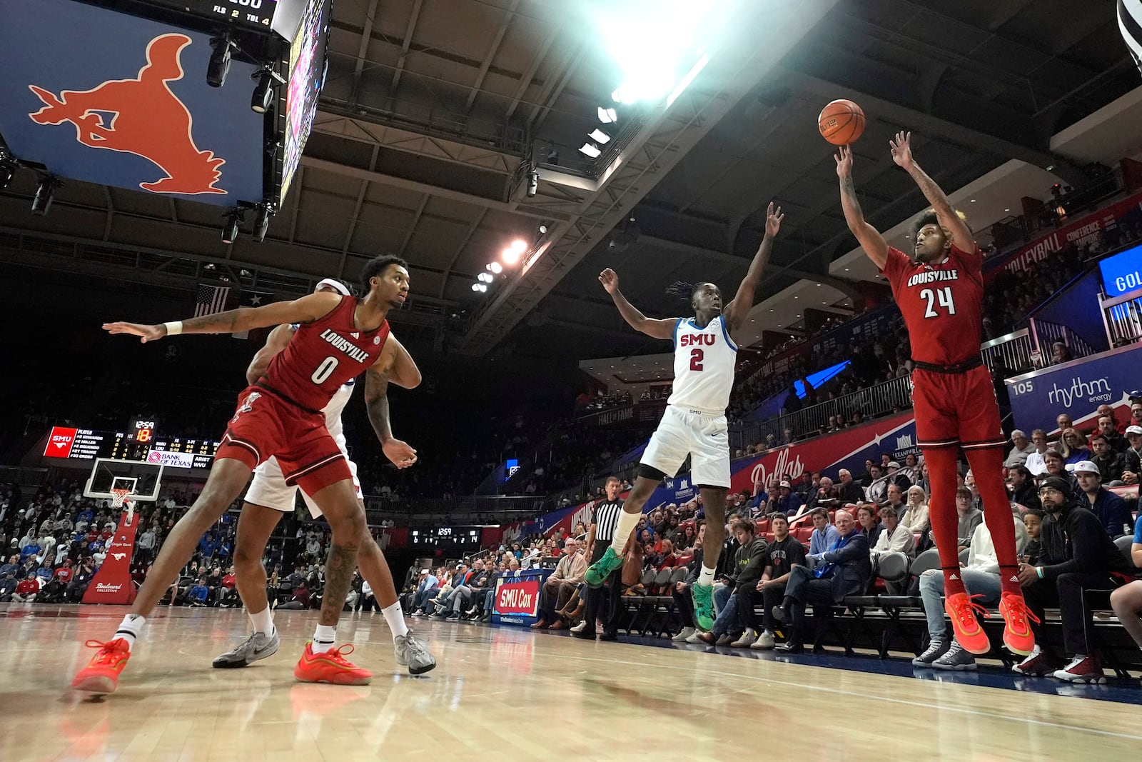 Louisville guard Chucky Hepburn (24) shoots with a block by teammate forward James Scott (0) against SMU defenders Yohan Traore, left, and Boopie Miller (2) during the first half of an NCAA college basketball game Tuesday, Jan. 21, 2025, in Dallas. (AP Photo/LM Otero)