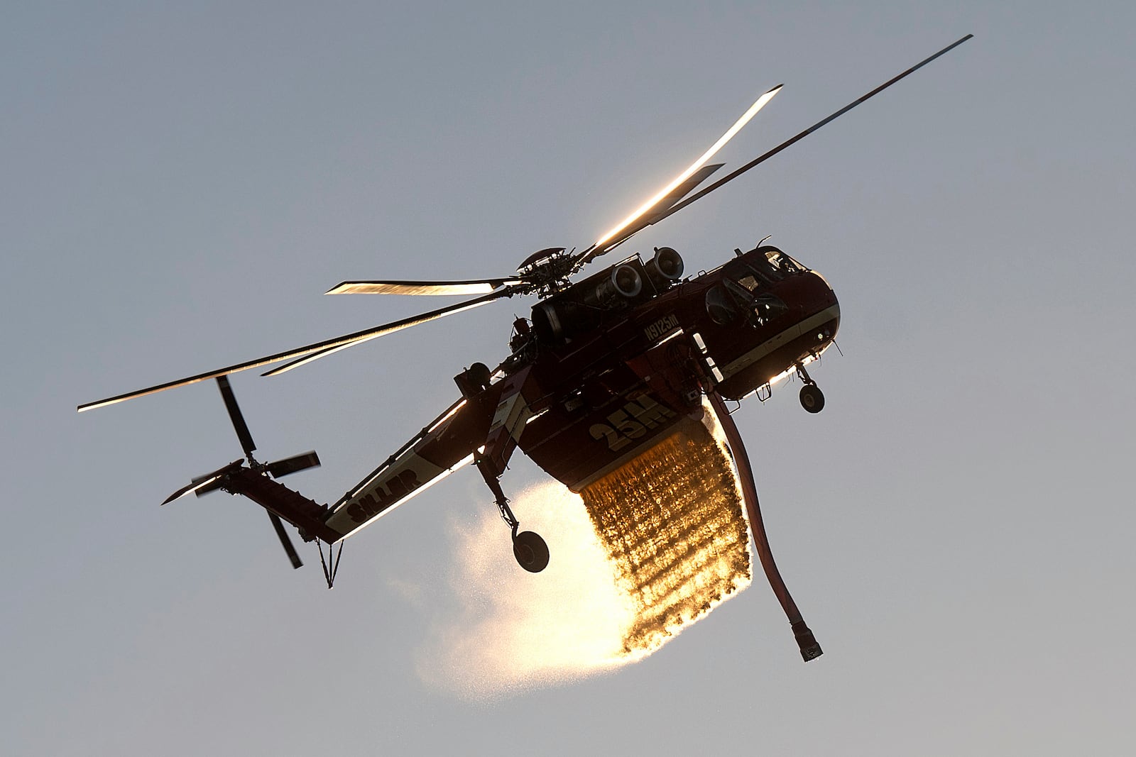 A helicopter drops water while battling the Mountain Fire along Waters Road in Moorpark, Calif., on Thursday, Nov. 7, 2024. (AP Photo/Noah Berger)