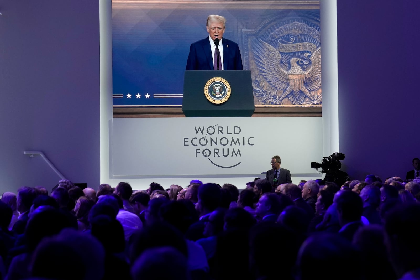 Attendees listen to a virtual speech delivered by U.S. president Donald Trump, at the Annual Meeting of World Economic Forum in Davos, Switzerland, Thursday, Jan. 23, 2025. (AP Photo/Markus Schreiber)