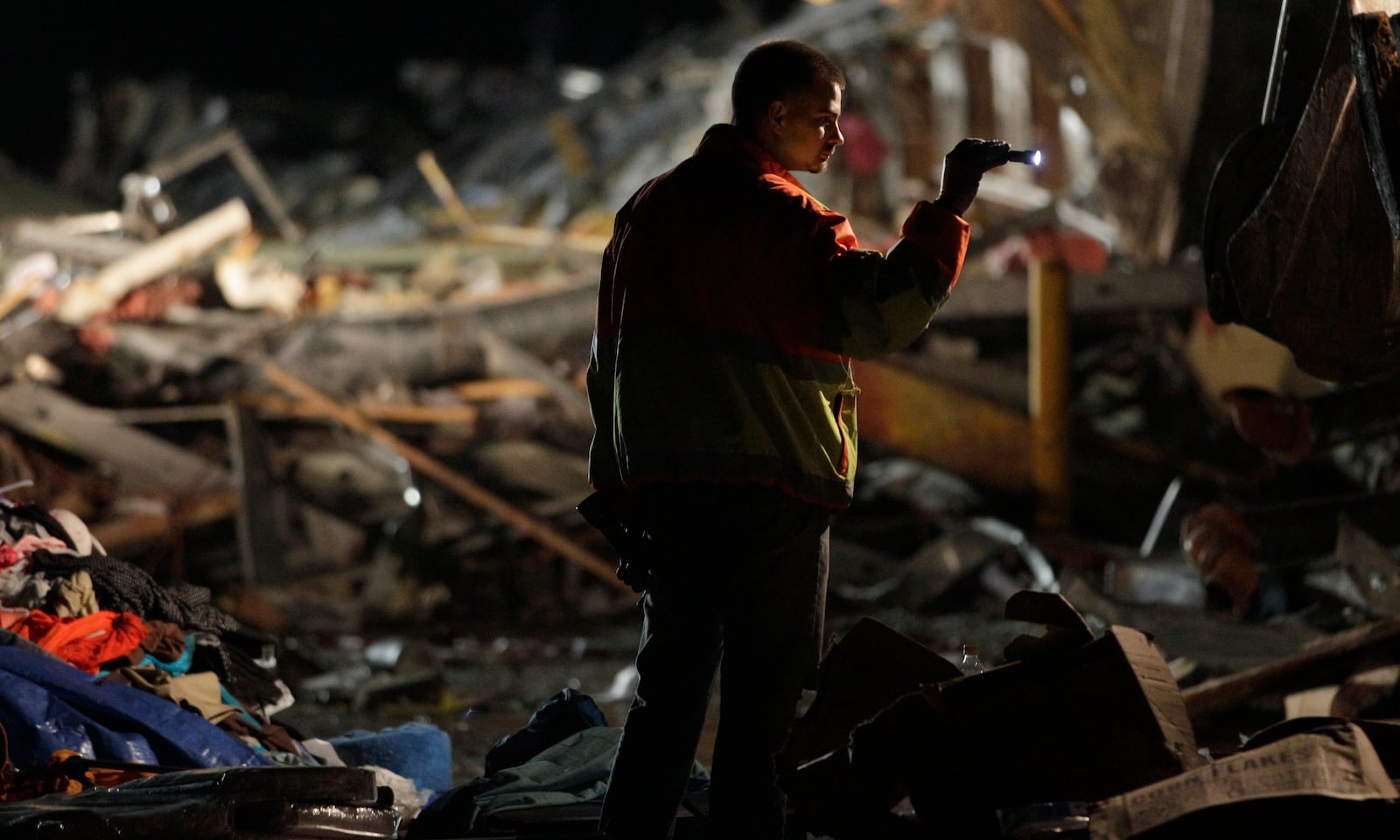 FILE- An emergency worker searches a Walmart store that was severely damaged by a tornado in Joplin, Mo., Sunday, May 22, 2011. (AP Photo/Charlie Riedel, File)