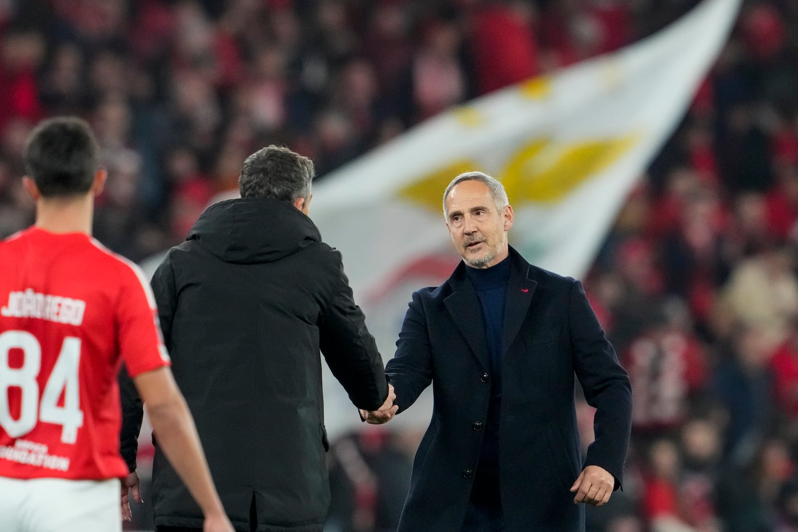 Monaco's head coach Adi Huetter, right, shakes hands with Benfica's head coach Bruno Lage at the end of the Champions League playoff second leg soccer match between SL Benfica and AS Monaco at the Luz stadium in Lisbon, Tuesday, Feb. 18, 2025. (AP Photo/Armando Franca)