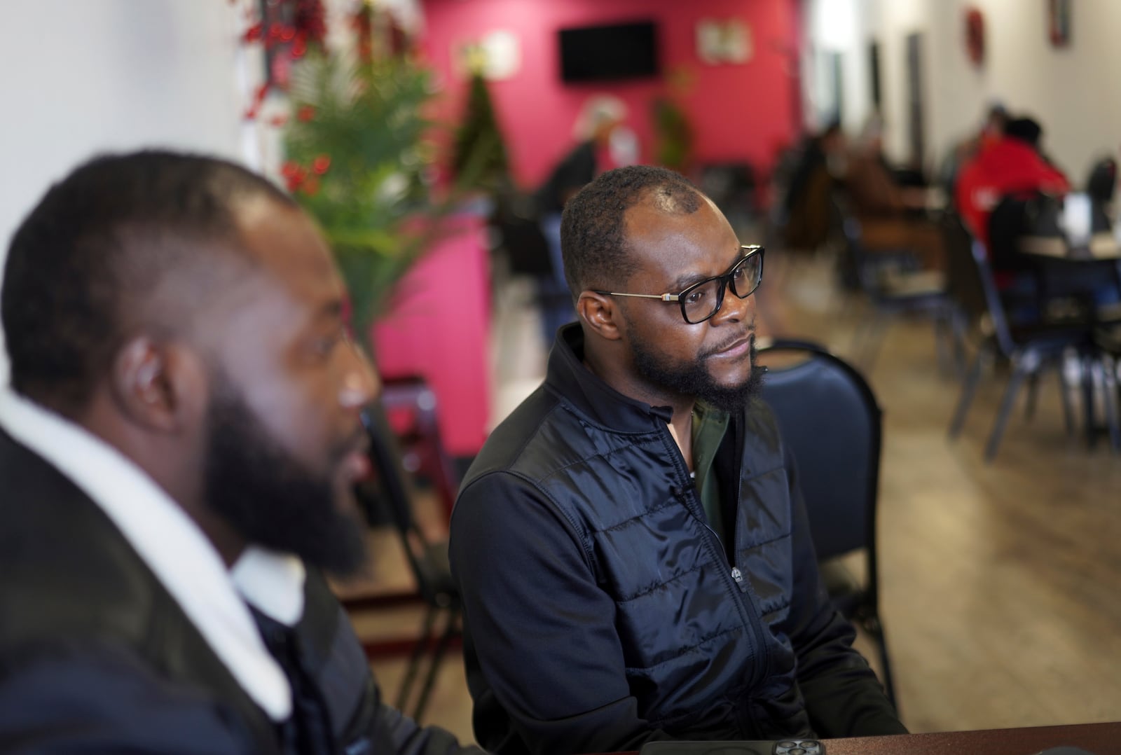 Viles Dorsainvil, executive director of the Haitian Community Help and Support Center at Rose Goute Creole Restaurant, sits with interpreter James Fleurijean, left, a board member of the Haitian Community Help and Support Center, in Springfield, Ohio, Saturday, January 25, 2025. (AP Photo/Jessie Wardarski)