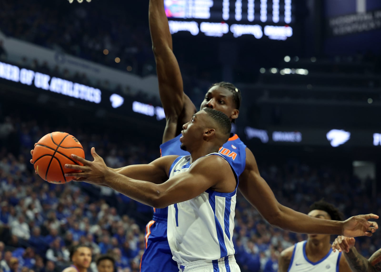 Kentucky's Lamont Butler (1), bottom shoots while defended by Florida's Rueben Chinyelu (9) during the first half of an NCAA college basketball game in Lexington, Ky., Saturday, Jan. 4, 2025. (AP Photo/James Crisp)