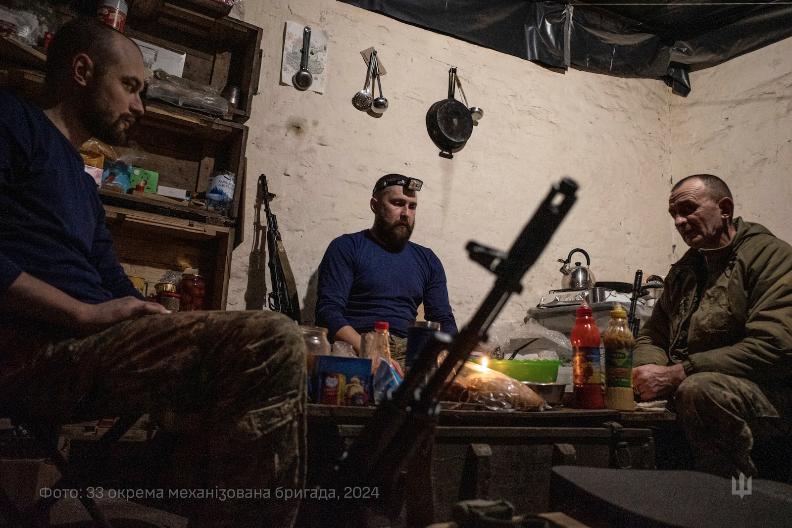 In this photo provided by Ukraine's 33rd Mechanised Brigade press service, servicemen prepare a festive dinner on Christmas Eve in a shelter on the frontline in the Dnipropetrovsk region, Ukraine, Tuesday, Dec. 24, 2024. (Volodymyr Petrov/Ukraine's 33rd Mechanised Brigade via AP)