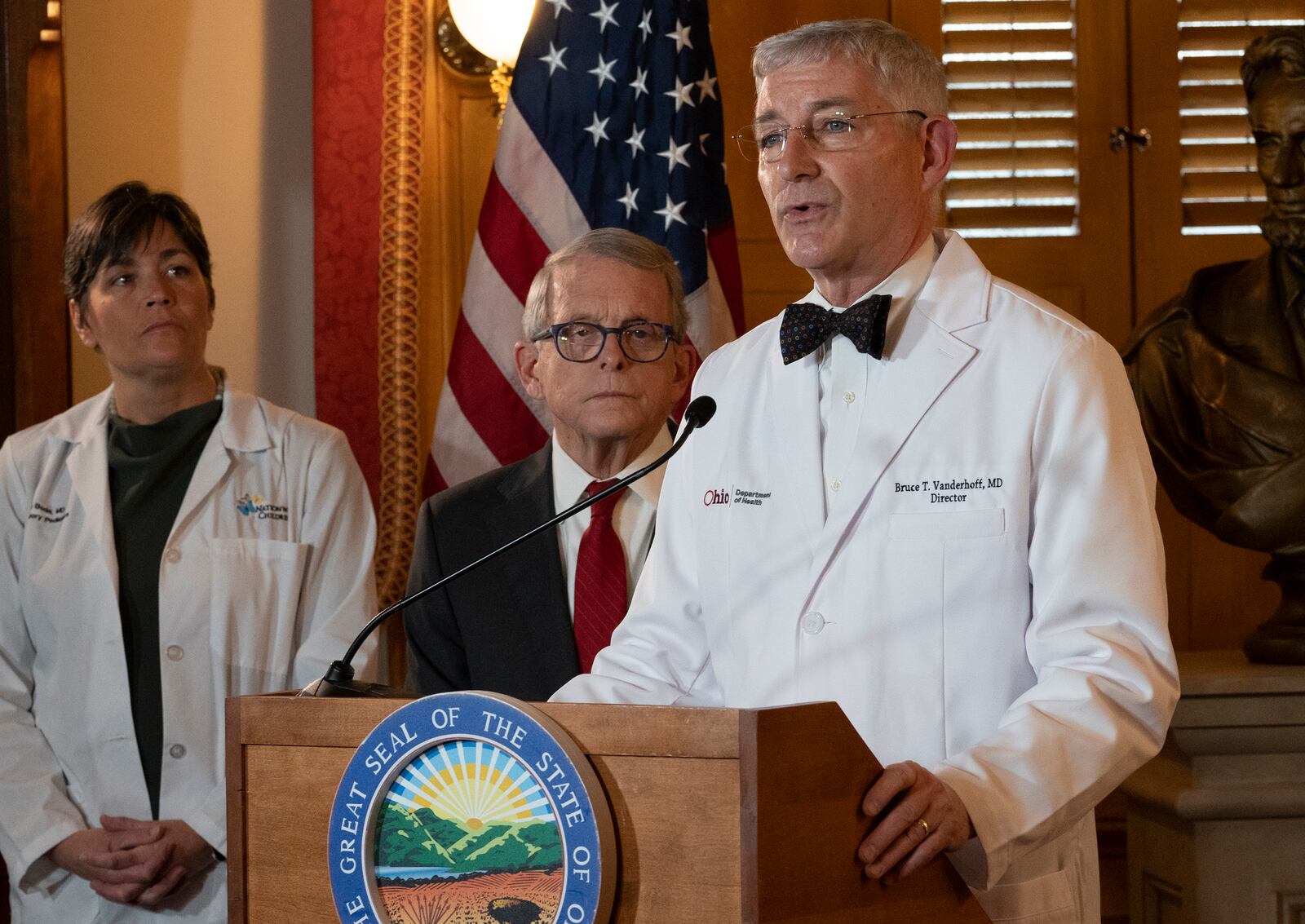 Ohio Department of Health Director Bruce Vanderhoff speaks while Gov. Mike DeWine and Dr. Sara Bode of Nationwide Children's Hospital stand behind him after DeWine vetoed legislation that would have blocked cities like Columbus from banning the sale of menthol cigarettes and flavored vapes, Thursday, Jan. 5, 2023. (Brooke LaValley/The Columbus Dispatch via AP)