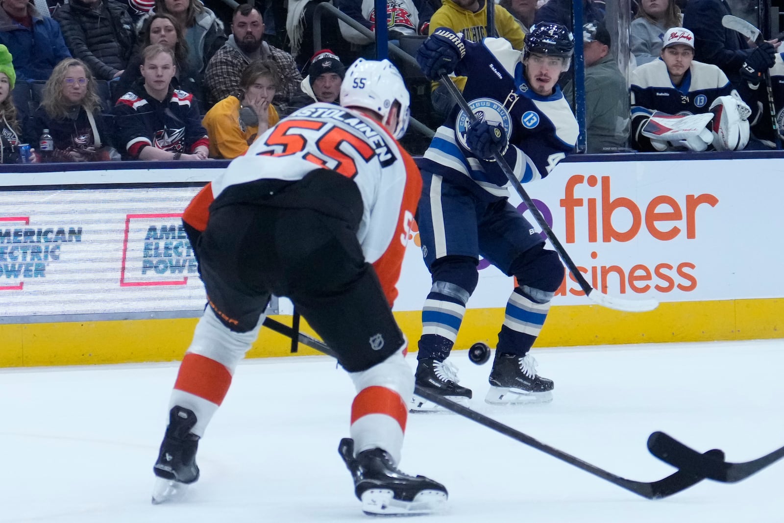 Columbus Blue Jackets' Cole Sillinger (4) shoots as Philadelphia Flyers' Rasmus Ristolainen (55) defends in the second period of an NHL hockey game Tuesday, Jan. 14, 2025, in Columbus, Ohio. (AP Photo/Sue Ogrocki)