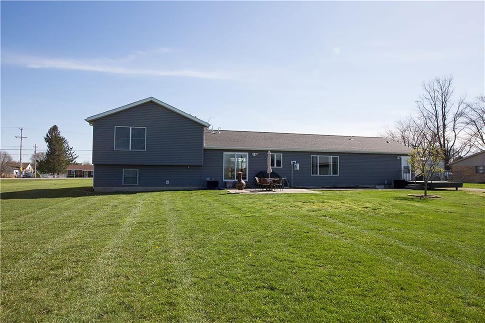 The rear of the house has two exterior doors, one leading to a concrete patio and the other to a                        wood deck with railing. CONTRIBUTED PHOTO