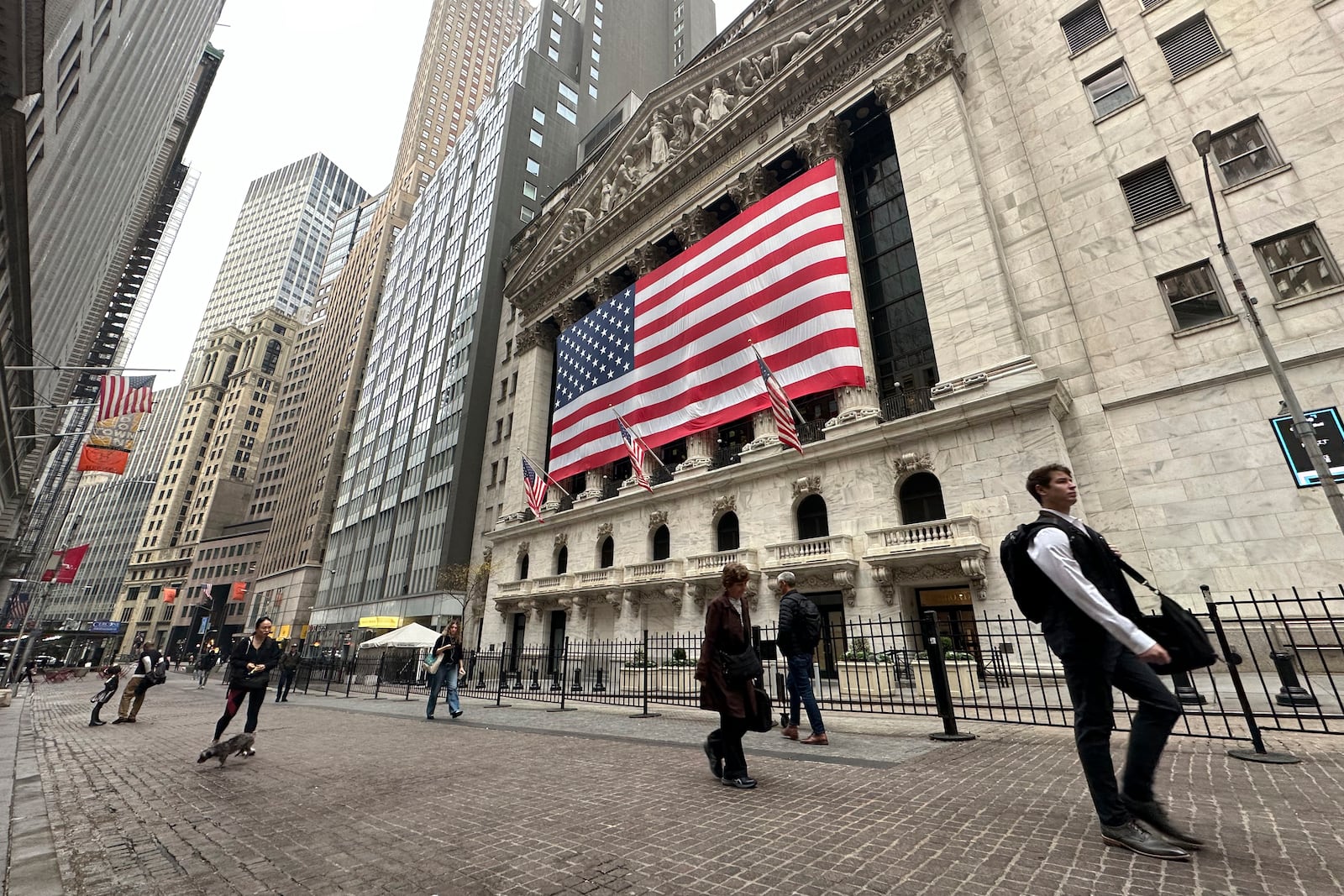 People pass the New York Stock Exchange in New York's Financial District on Tuesday, Nov. 5, 2024. (AP Photo/Peter Morgan)