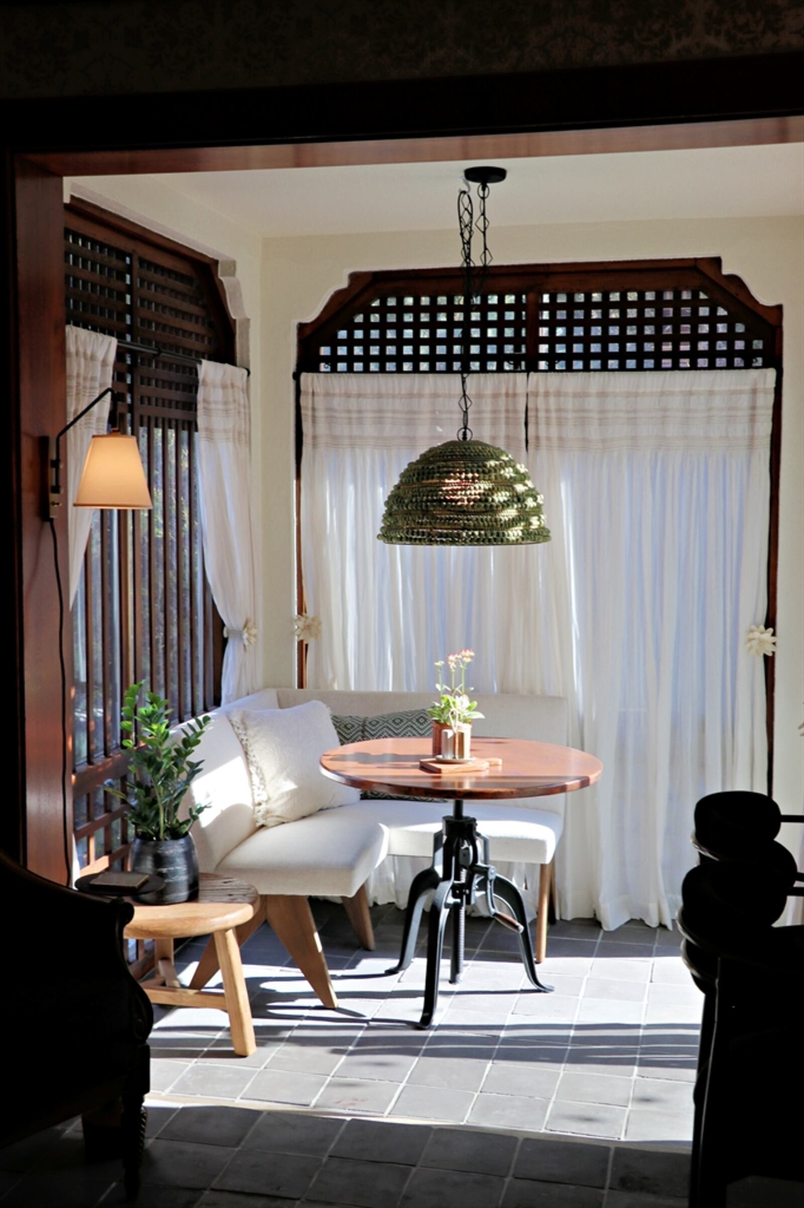 A breakfast nook is filled with floor-to-ceiling windows covered with detailed wood frames. 