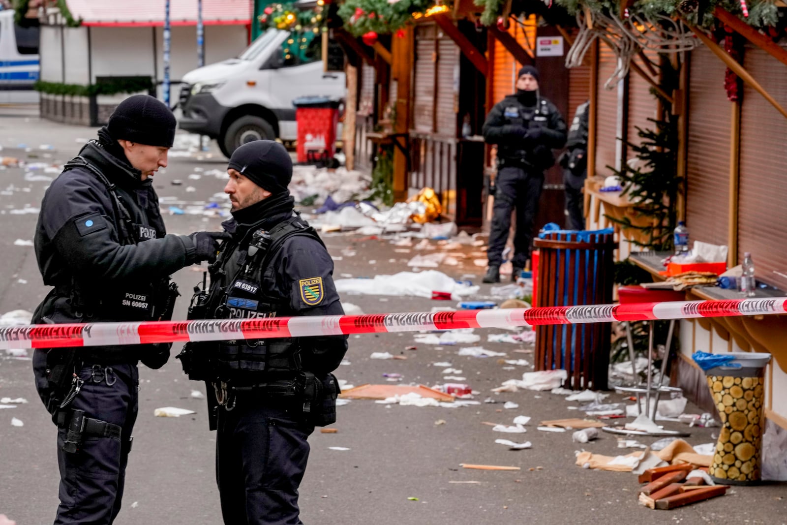 Policemen guard a Christmas Market, where a car drove into a crowd on Friday evening, in Magdeburg, Germany, Saturday, Dec. 21, 2024. (AP Photo/Michael Probst)