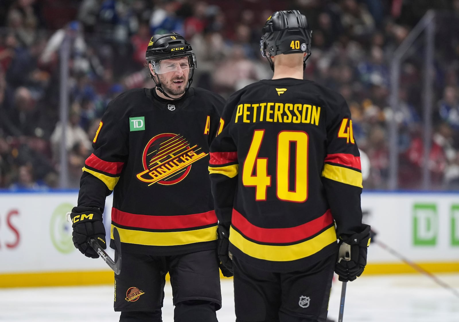 Vancouver Canucks' J.T. Miller talks to Elias Pettersson (40) before the second period of an NHL hockey game against Washington Capitals in Vancouver, British Columbia, on Saturday, Jan. 25, 2025. (Darryl Dyck/The Canadian Press via AP)