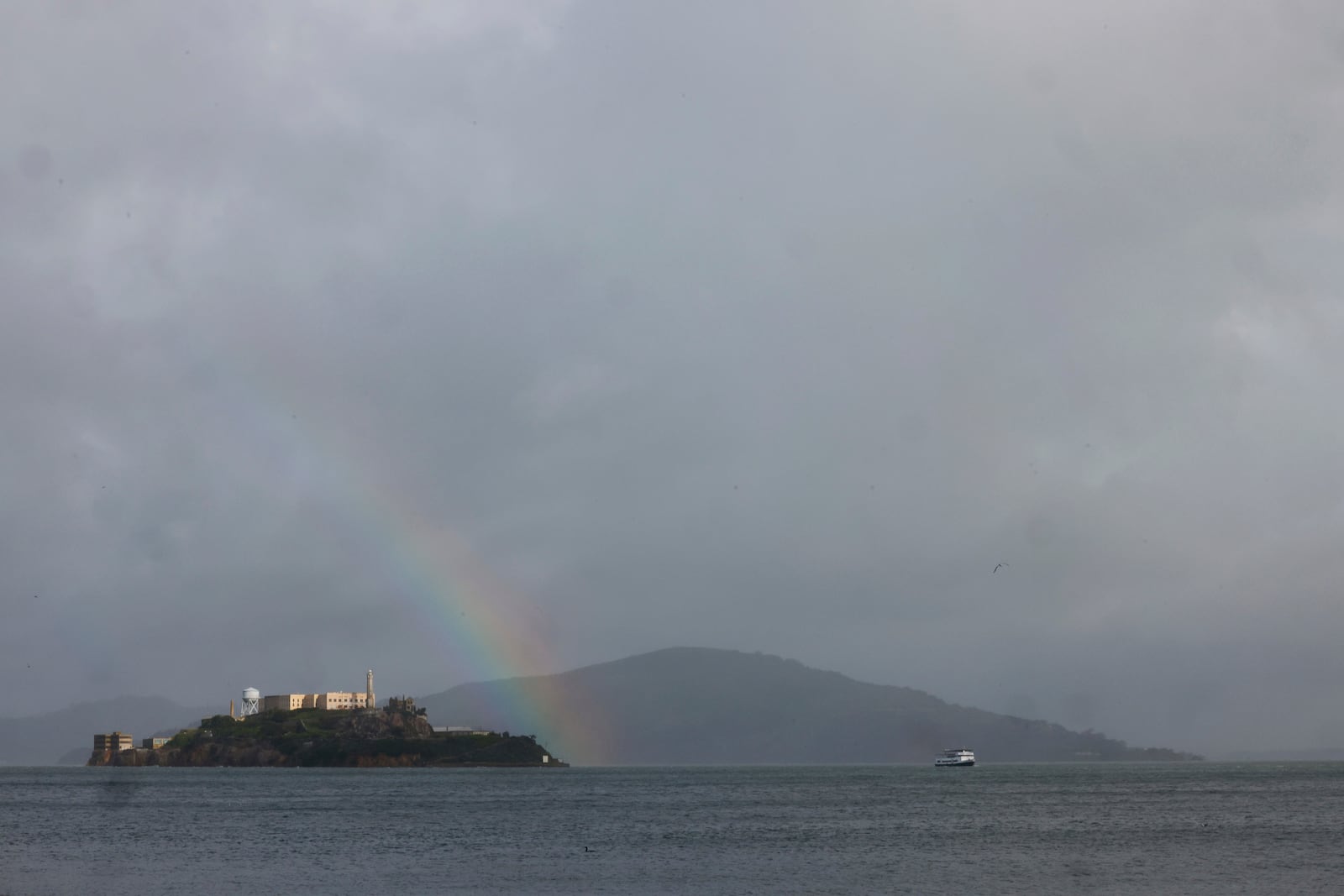 A rainbow appears over Alcatraz on a morning with alternating rain and sun on Thursday, Feb. 13, 2025, in San Francisco. (Lea Suzuki/San Francisco Chronicle via AP)